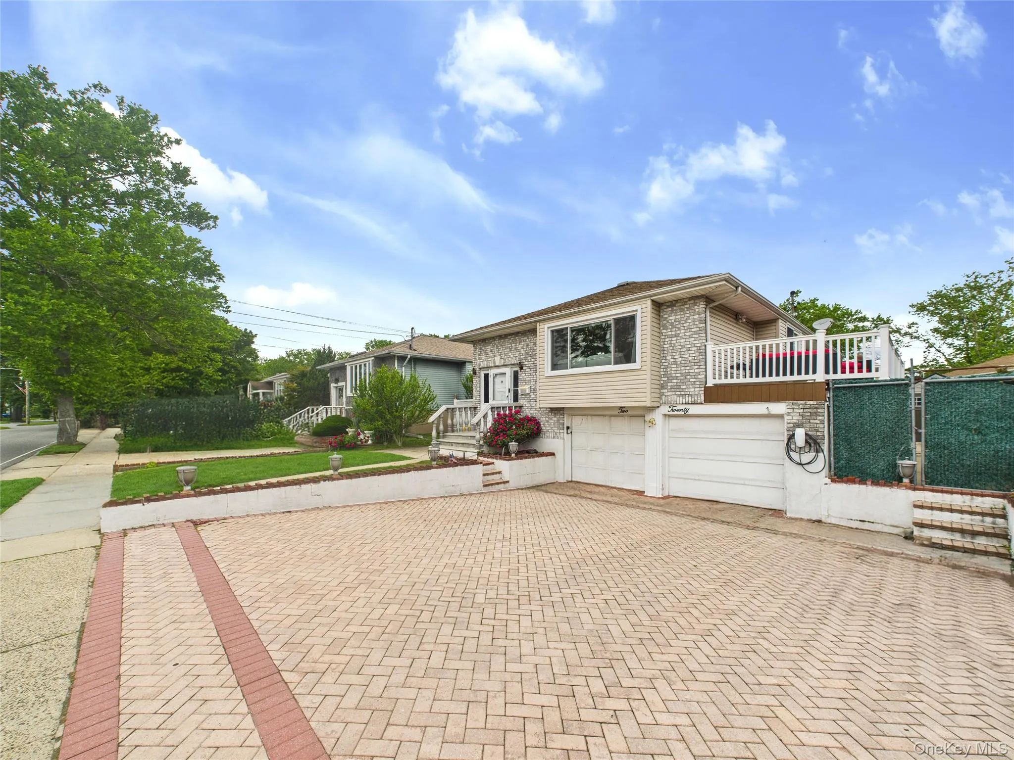 View of front facade with decorative driveway, an attached garage, and brick siding View of front facade with decorative driveway, an attached garage, and brick siding