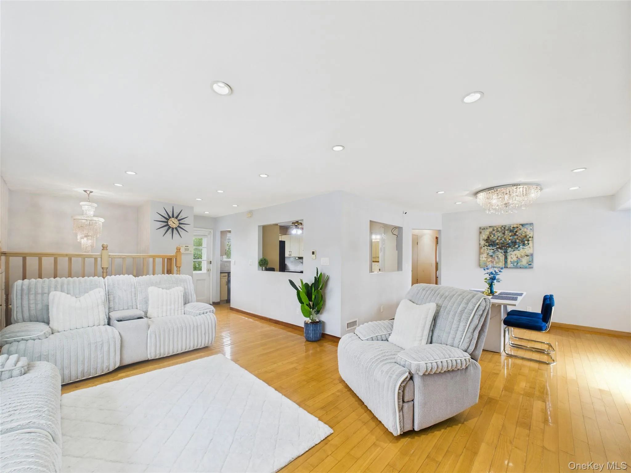 Living room featuring baseboards, a chandelier, light wood finished floors, and recessed lighting Living room featuring baseboards, a chandelier, light wood finished floors, and recessed lighting