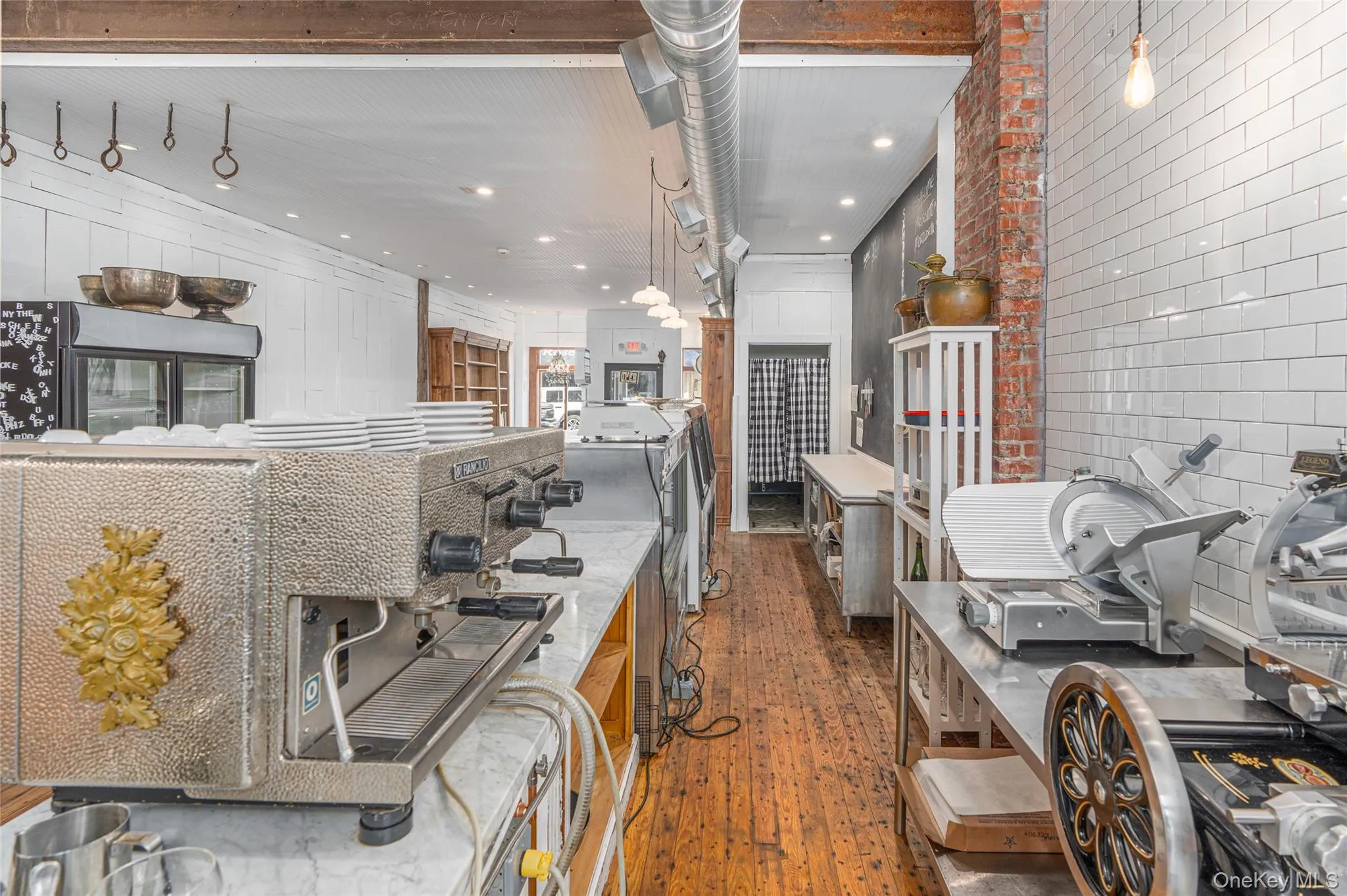 Kitchen with brick wall, dark hardwood / wood-style flooring, and decorative light fixtures Kitchen with brick wall, dark hardwood / wood-style flooring, and decorative light fixtures