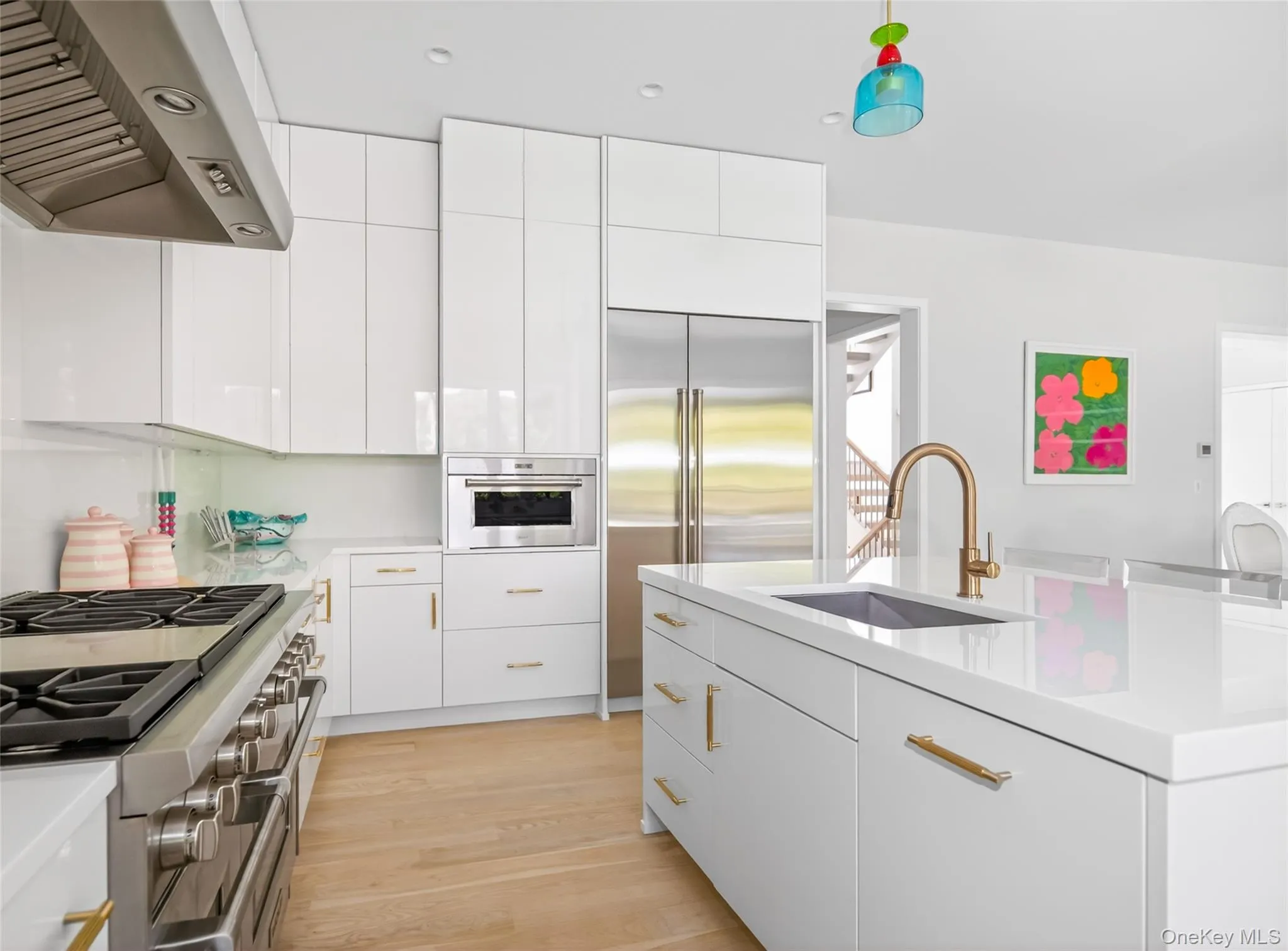 Contemporary kitchen featuring white flat-panel cabinetry, a stainless steel range with matching hood, and built-in microwave Contemporary kitchen featuring white flat-panel cabinetry, a stainless steel range with matching hood, and built-in microwave