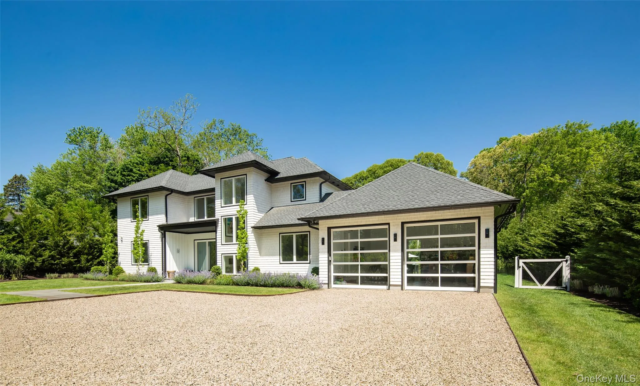 Modern residence featuring a light-colored exterior with dark trim accents Modern residence featuring a light-colored exterior with dark trim accents