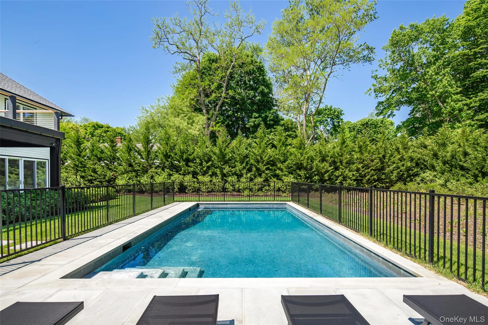 Rectangular inground pool featuring integrated steps and a surrounding patio Rectangular inground pool featuring integrated steps and a surrounding patio