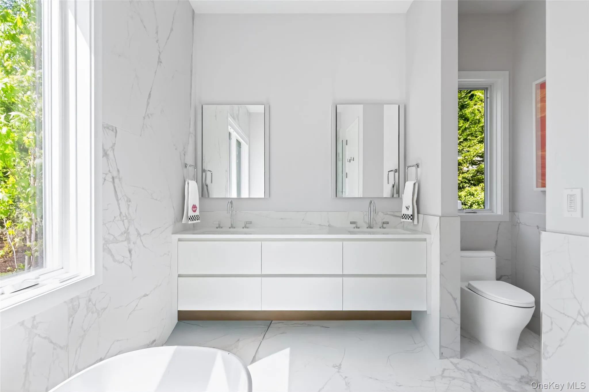 Primary Bathroom featuring a dual vanity with white cabinetry, square undermount sinks, and polished chrome fixtures Primary Bathroom featuring a dual vanity with white cabinetry, square undermount sinks, and polished chrome fixtures
