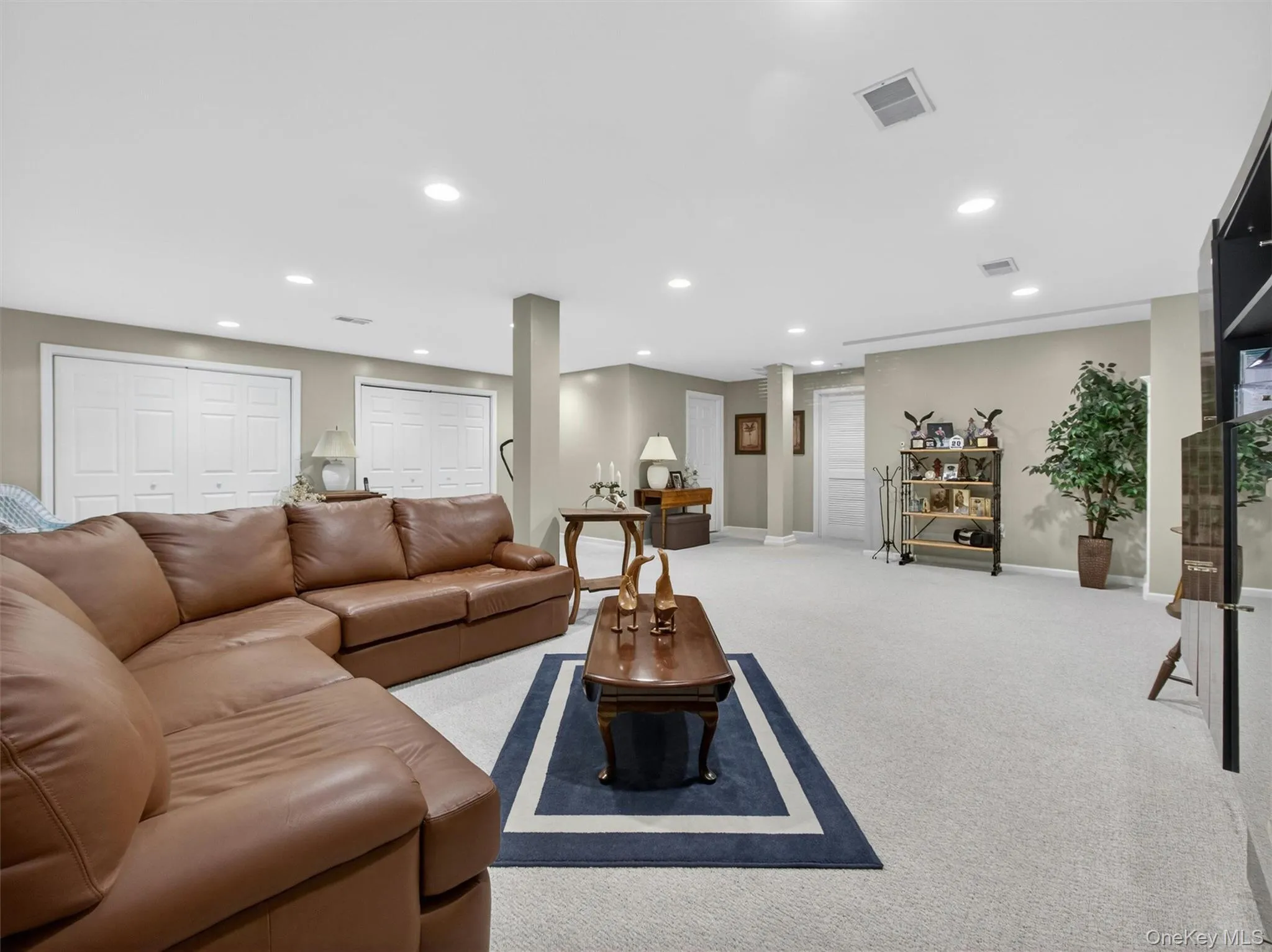 Another basement view featuring two large double closets, a fully finished bathroom with shower stall, and door leading to the utility room with additional storage. Another basement view featuring two large double closets, a fully finished bathroom with shower stall, and door leading to the utility room with additional storage.