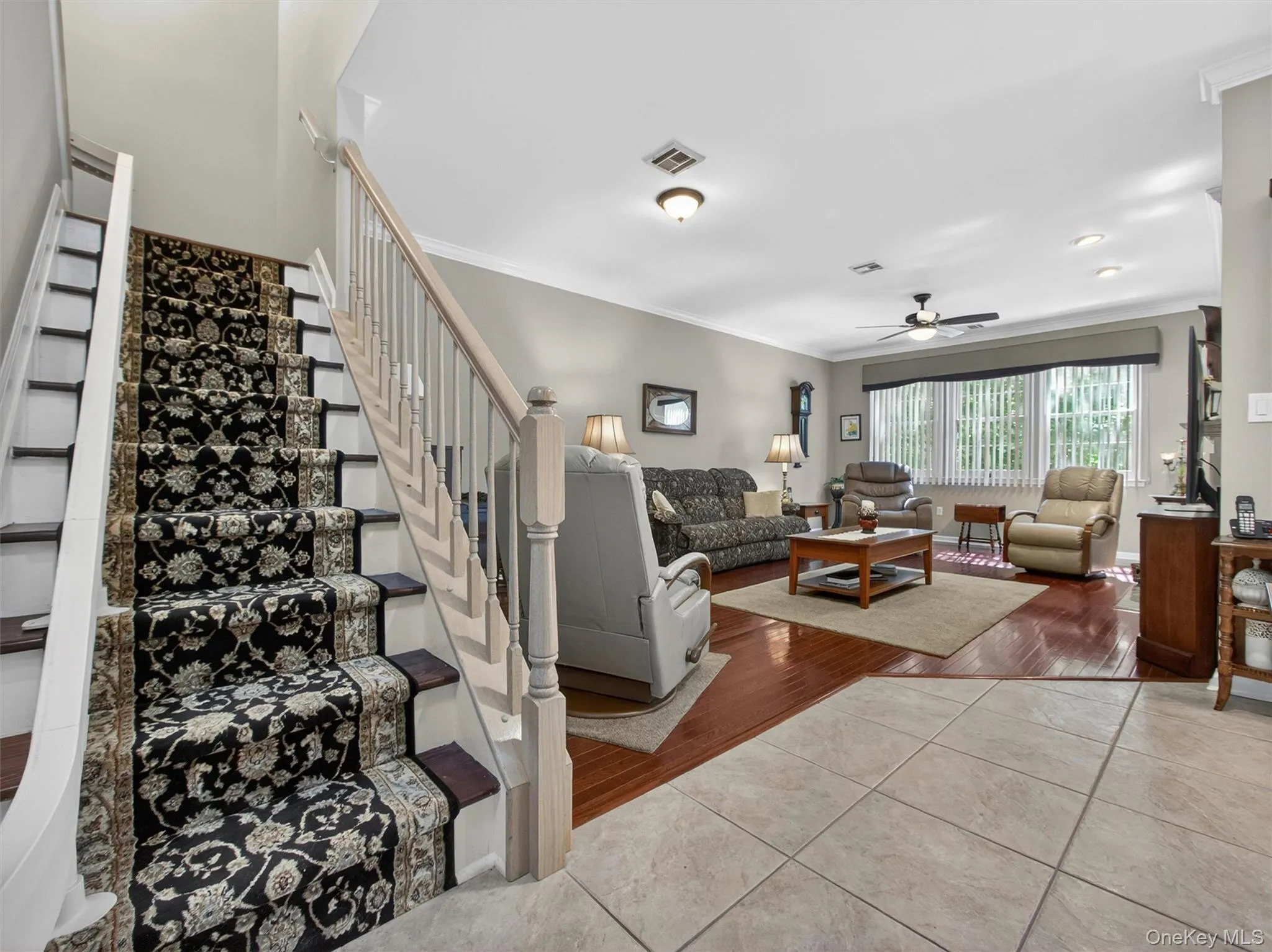 View from the entry foyer thru to the living room and stairs leading to bedroom level. View from the entry foyer thru to the living room and stairs leading to bedroom level.