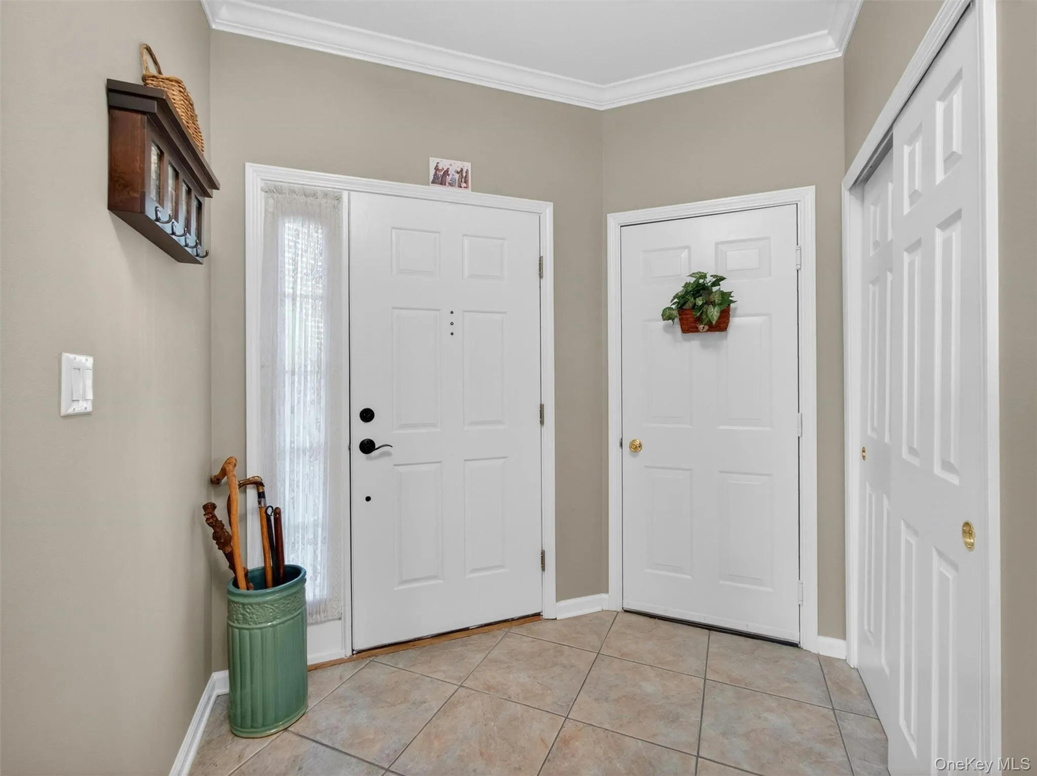 Doors leading to the entry pathway, the garage, and a closet. Doors leading to the entry pathway, the garage, and a closet.
