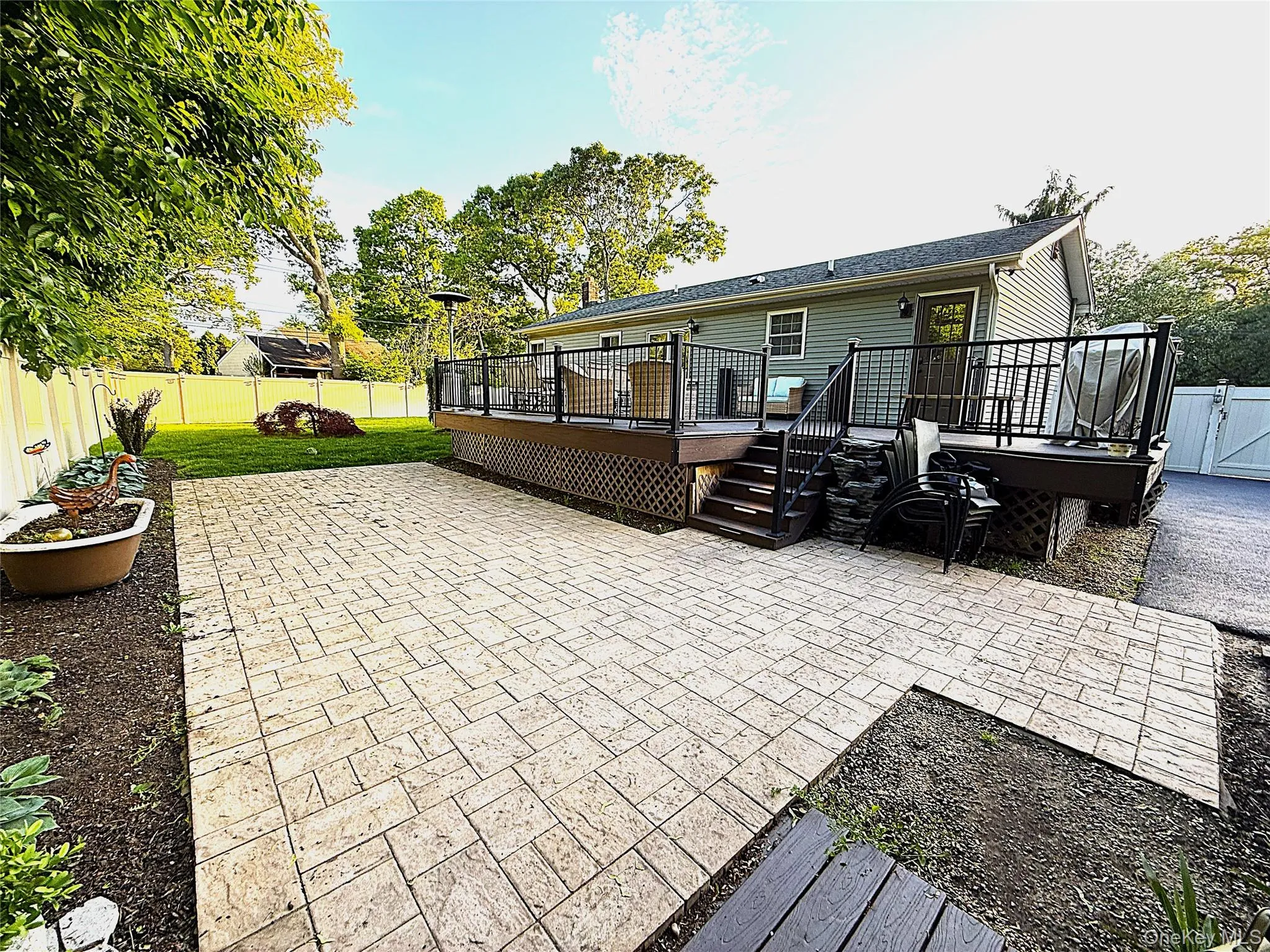 Patio featuring paver flooring, bordered by a garden bed with hostas Patio featuring paver flooring, bordered by a garden bed with hostas