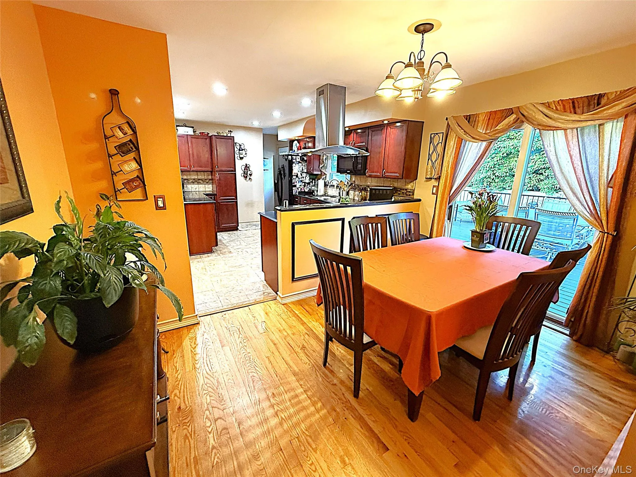Dining area featuring hardwood flooring, a multi-light chandelier, and a sliding glass door providing exterior access Dining area featuring hardwood flooring, a multi-light chandelier, and a sliding glass door providing exterior access