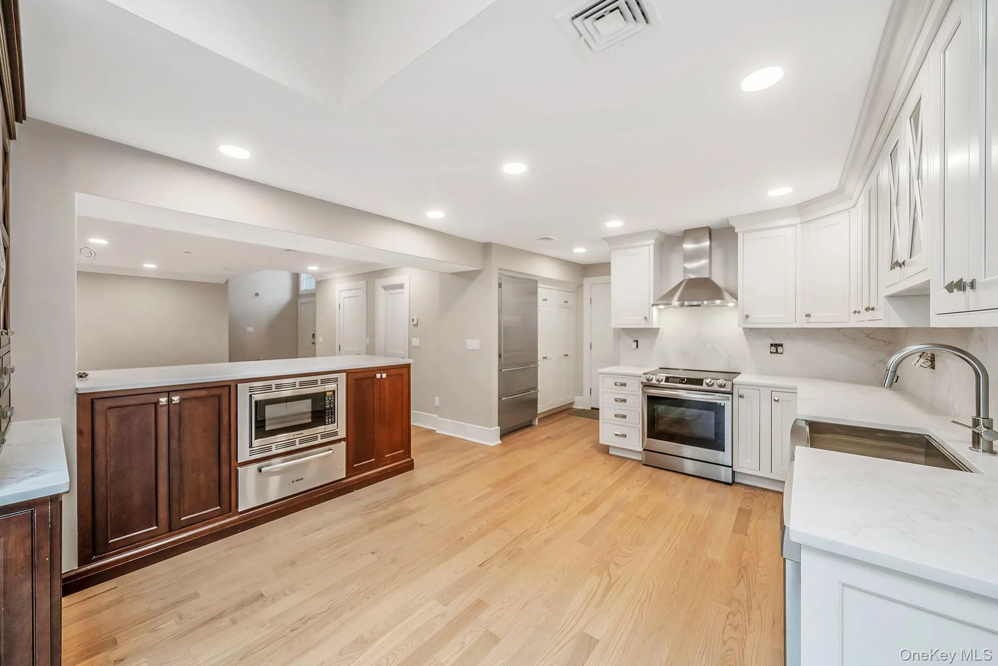 Modern kitchen featuring light wood-finish flooring and recessed lighting Modern kitchen featuring light wood-finish flooring and recessed lighting
