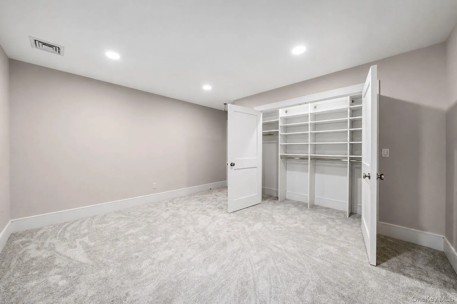 Room featuring light gray wall paint, white baseboards, and light gray patterned carpeting Room featuring light gray wall paint, white baseboards, and light gray patterned carpeting