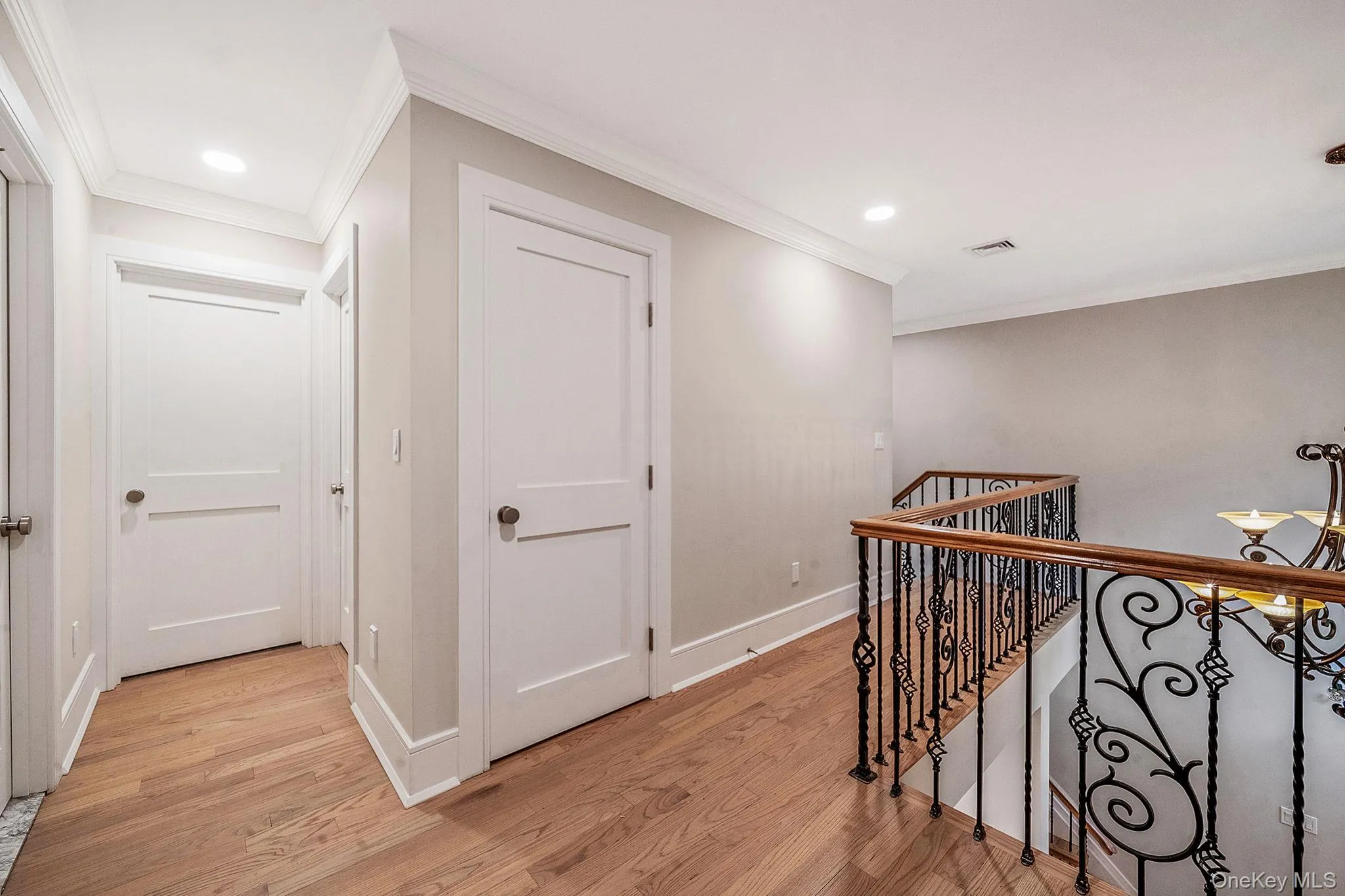Hardwood flooring throughout this upper-level hallway featuring recessed lighting and crown molding Hardwood flooring throughout this upper-level hallway featuring recessed lighting and crown molding