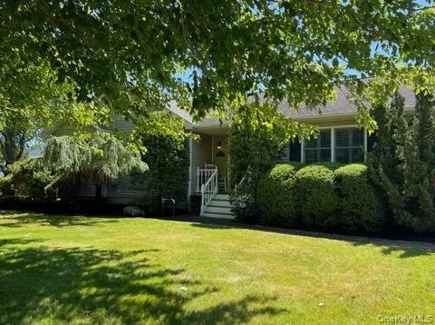 Ranch-style exterior featuring horizontal siding, dark shutters, manicured landscaping, and a front porch with white railings Ranch-style exterior featuring horizontal siding, dark shutters, manicured landscaping, and a front porch with white railings