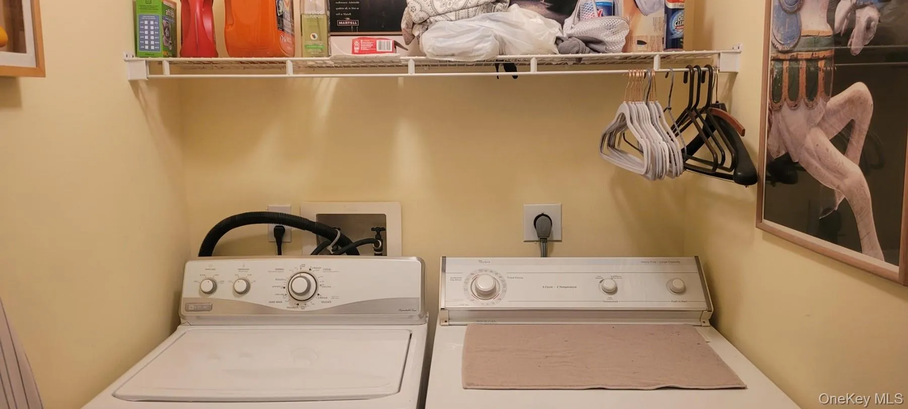 Dedicated First Floor laundry area featuring a wire storage shelf, light-toned walls, and utility hookups Dedicated First Floor laundry area featuring a wire storage shelf, light-toned walls, and utility hookups