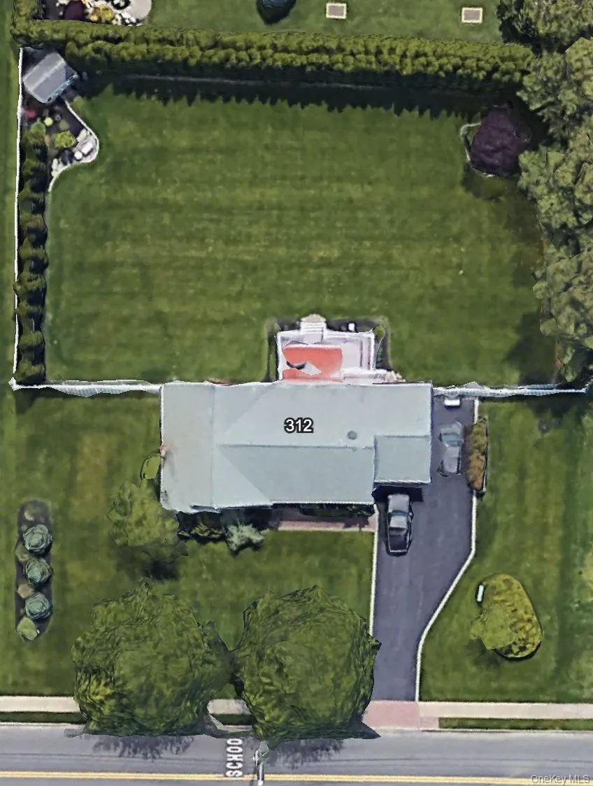 Expansive property featuring a large green lawn, mature perimeter hedging, a detached shed, and a paved driveway Expansive property featuring a large green lawn, mature perimeter hedging, a detached shed, and a paved driveway