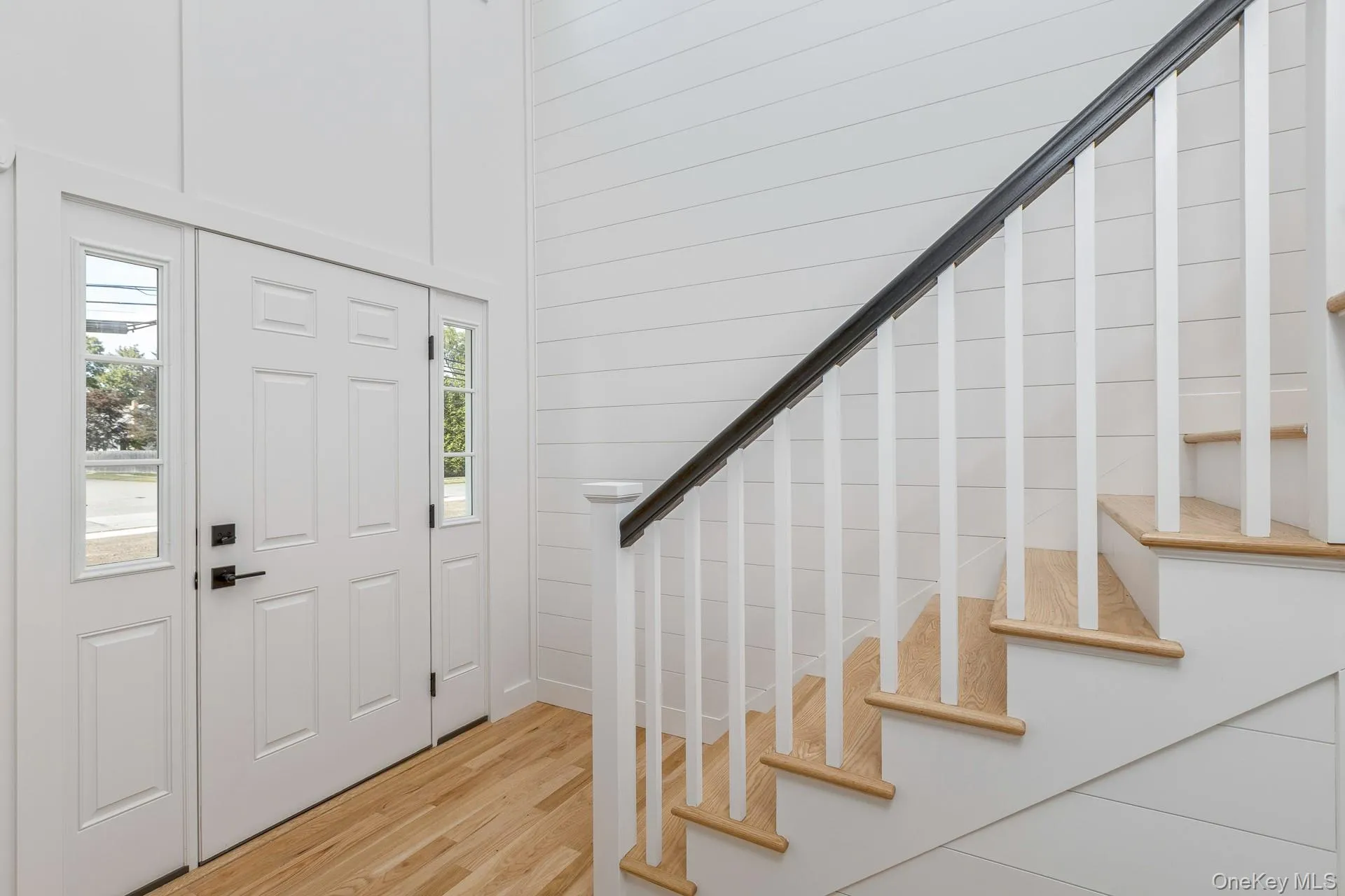 Entrance foyer with wood finished floors and stairs Entrance foyer with wood finished floors and stairs