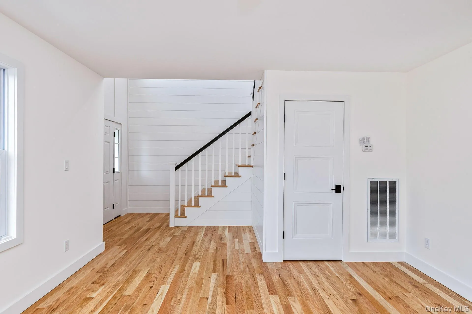 Entrance foyer featuring stairs and light wood-style flooring Entrance foyer featuring stairs and light wood-style flooring