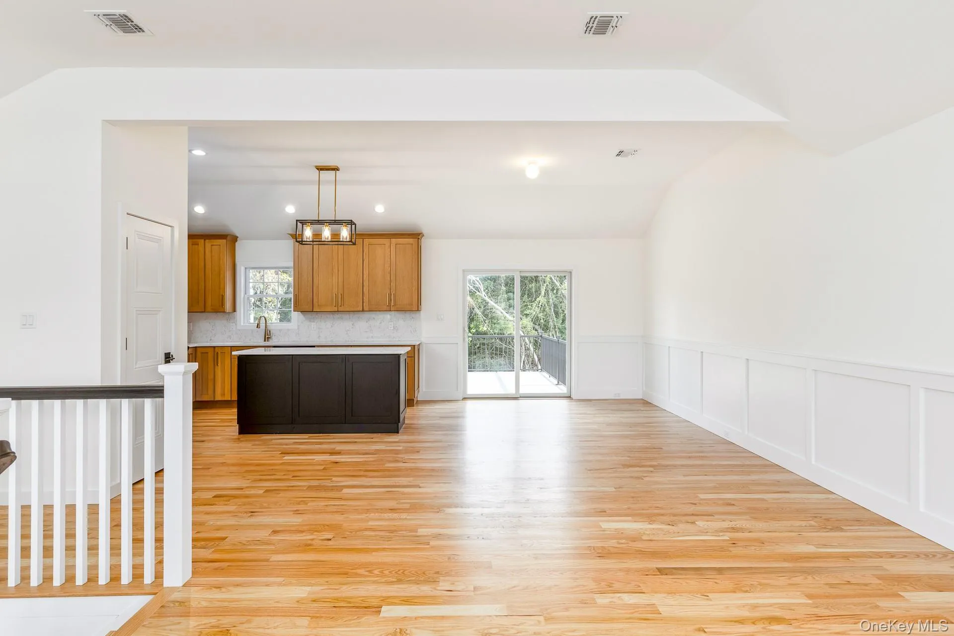 Kitchen with brown cabinets, light wood-type flooring, light countertops, decorative light fixtures, and vaulted ceiling Kitchen with brown cabinets, light wood-type flooring, light countertops, decorative light fixtures, and vaulted ceiling
