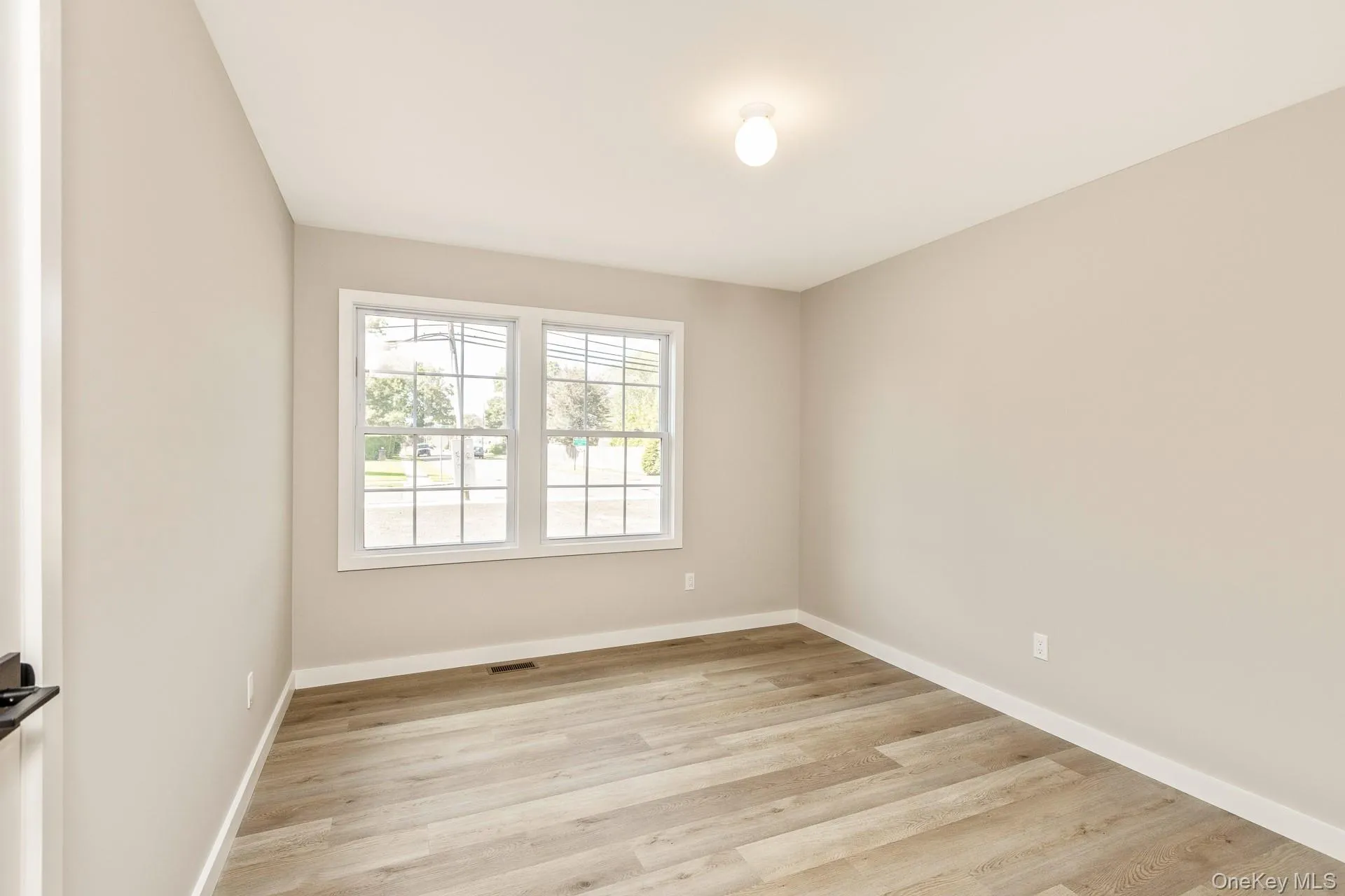 Spare room with light wood-type flooring and baseboards Spare room with light wood-type flooring and baseboards