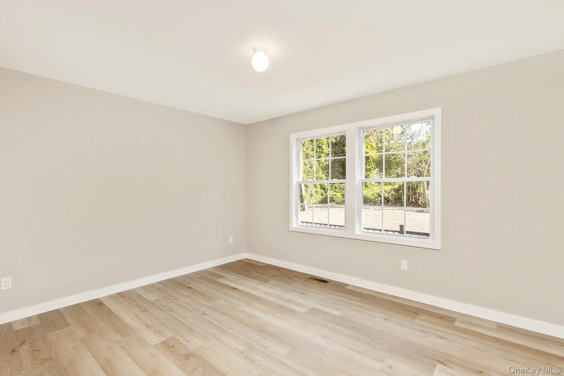 Spare room with light wood-style floors and baseboards Spare room with light wood-style floors and baseboards