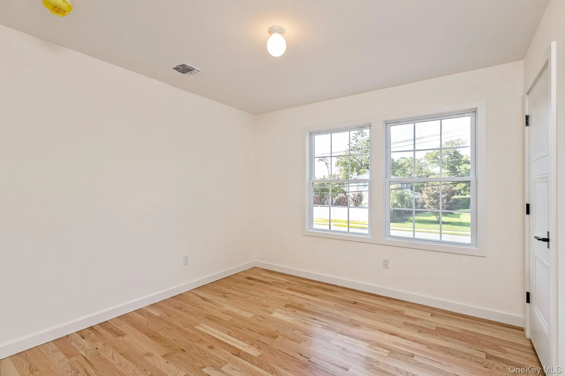 Empty room featuring light wood-type flooring and baseboards Empty room featuring light wood-type flooring and baseboards