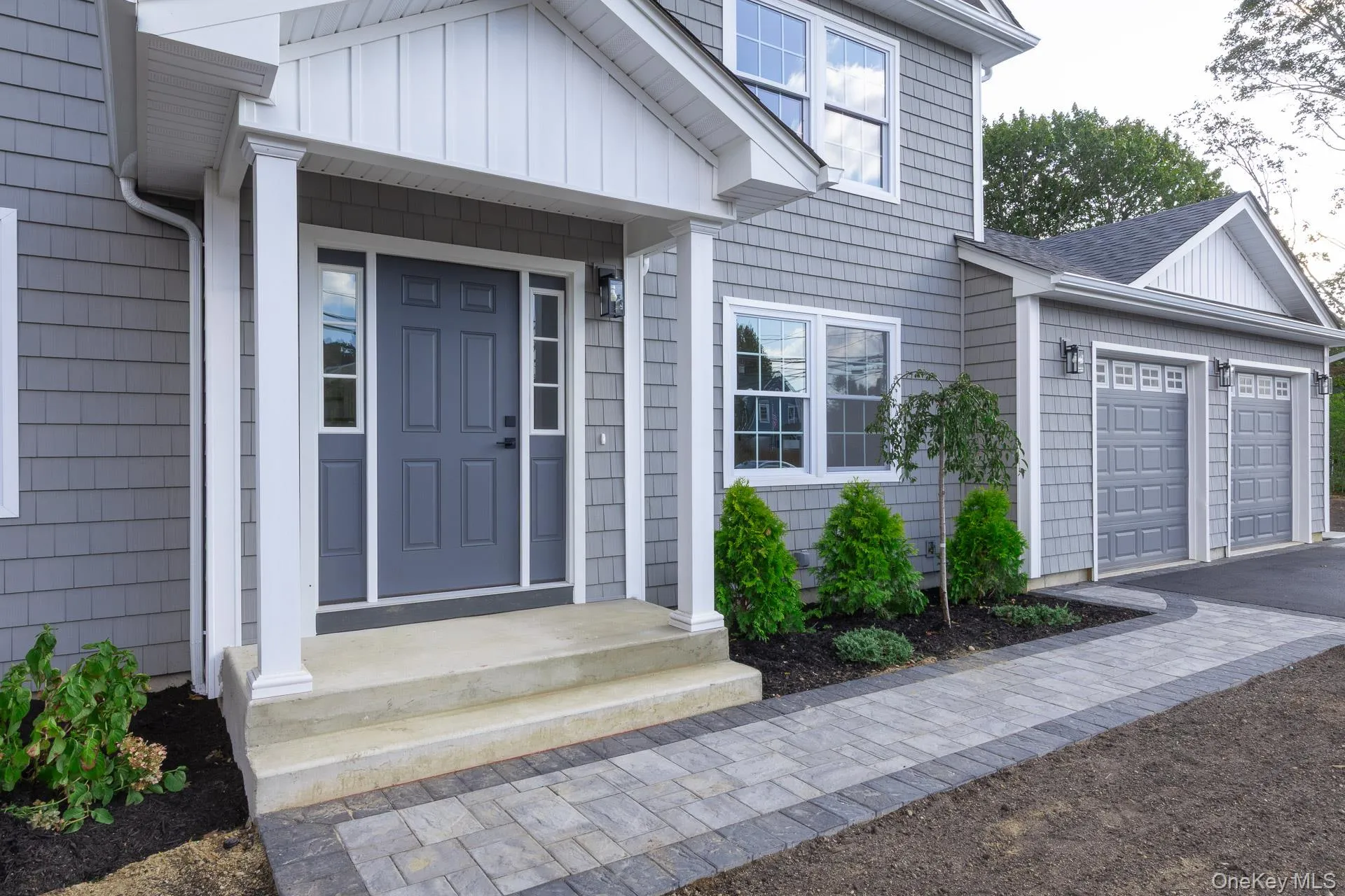 Property entrance with an attached garage, board and batten siding, roof with shingles, and asphalt driveway Property entrance with an attached garage, board and batten siding, roof with shingles, and asphalt driveway