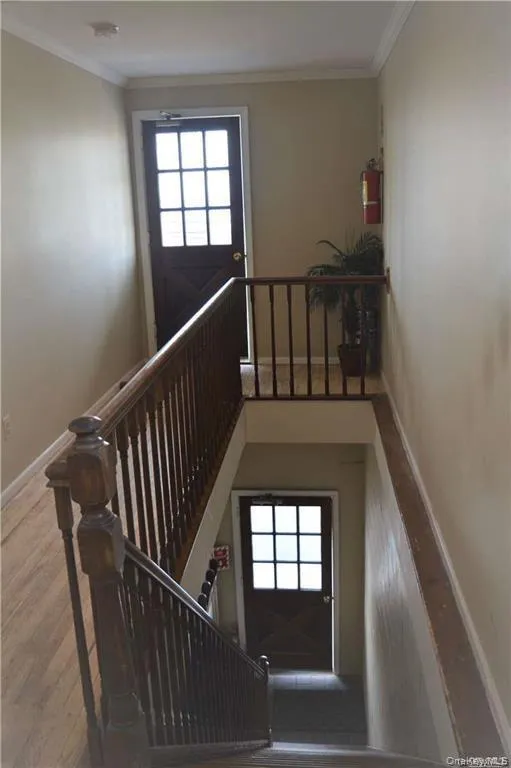 Multi-level interior featuring wood-finish flooring and wood banisters Multi-level interior featuring wood-finish flooring and wood banisters