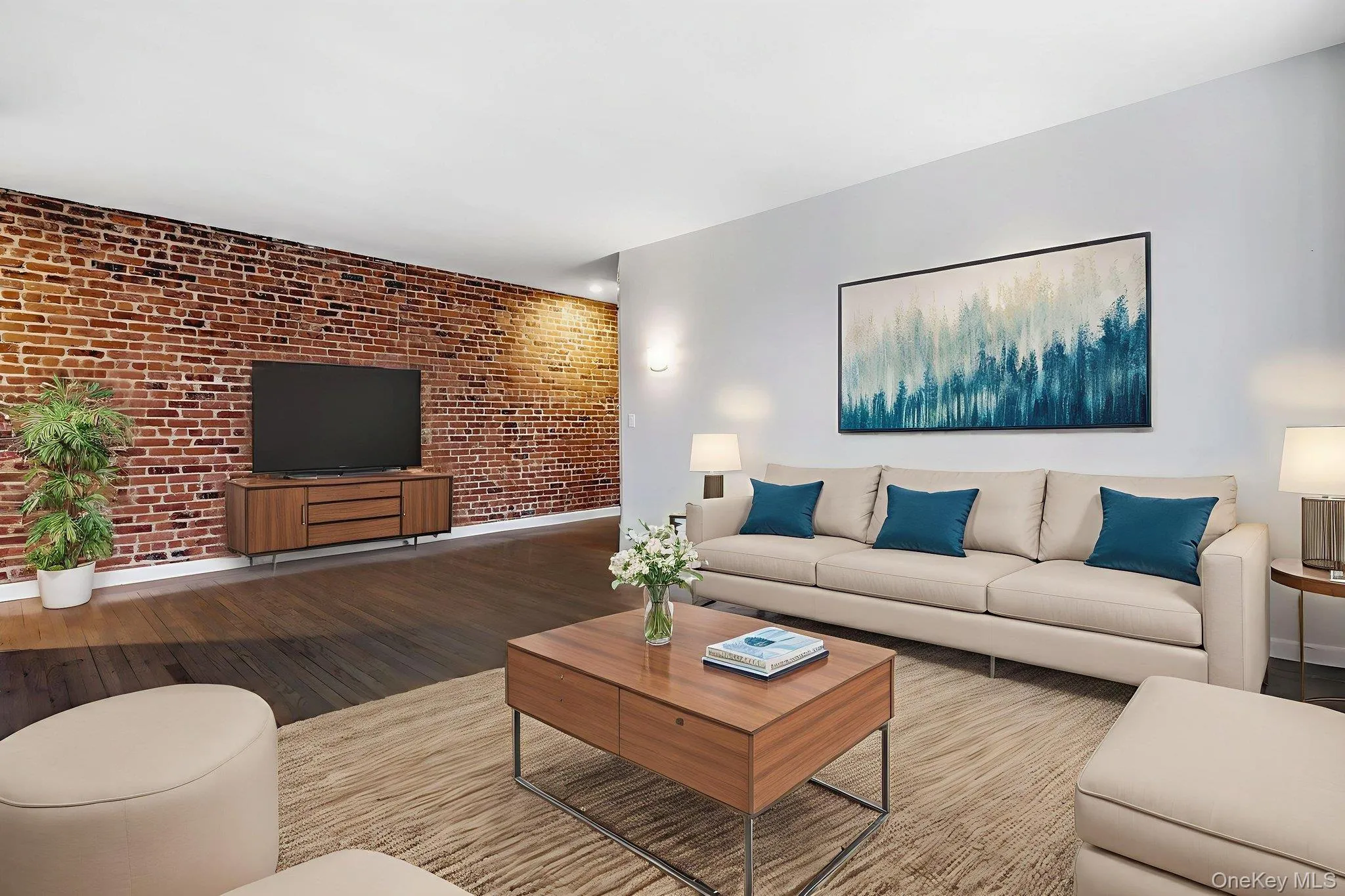 Virtually StagedLiving area with brick wall, wood finished floors, and an accent wall Virtually StagedLiving area with brick wall, wood finished floors, and an accent wall