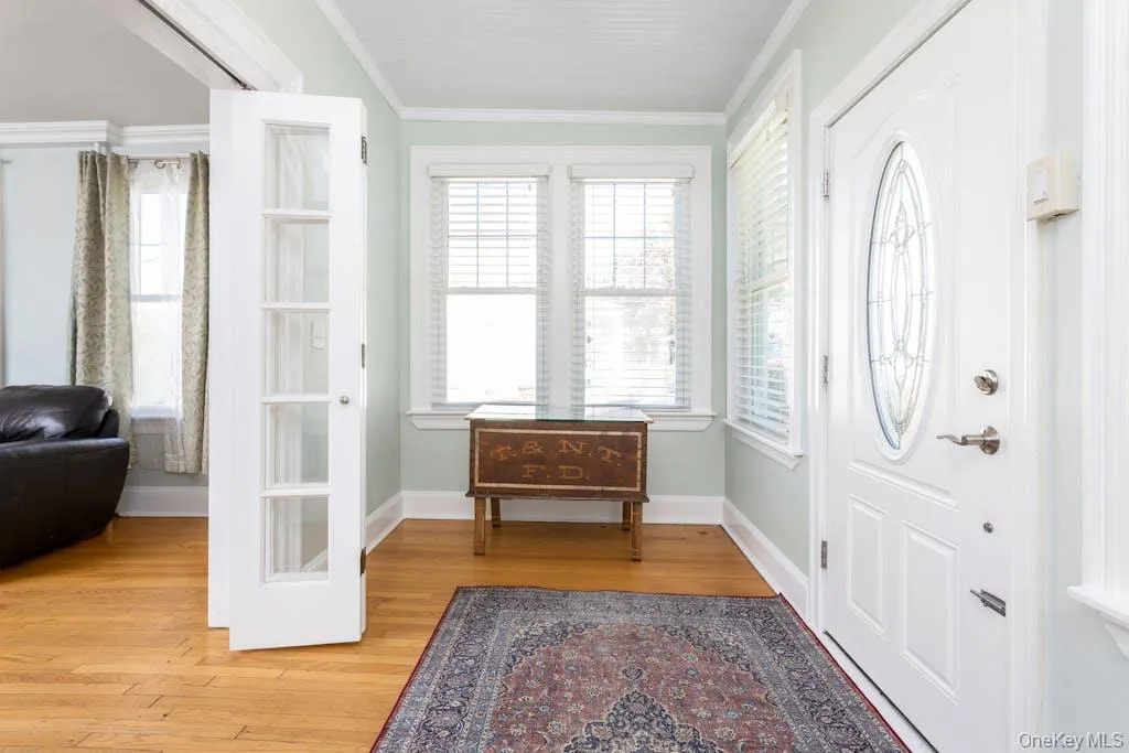 Foyer entrance/ Enclosed Porch with crown molding and hardwood flooring, French Doors into Living Room Foyer entrance/ Enclosed Porch with crown molding and hardwood flooring, French Doors into Living Room