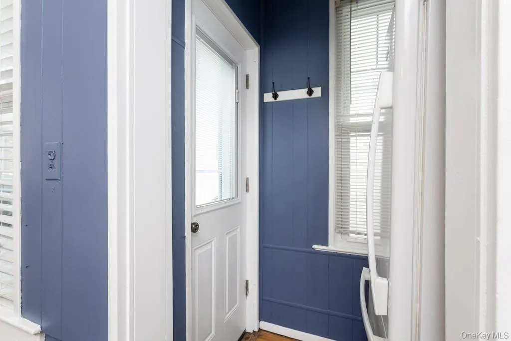 Doorway to outside with plenty of natural light and wood walls Doorway to outside with plenty of natural light and wood walls