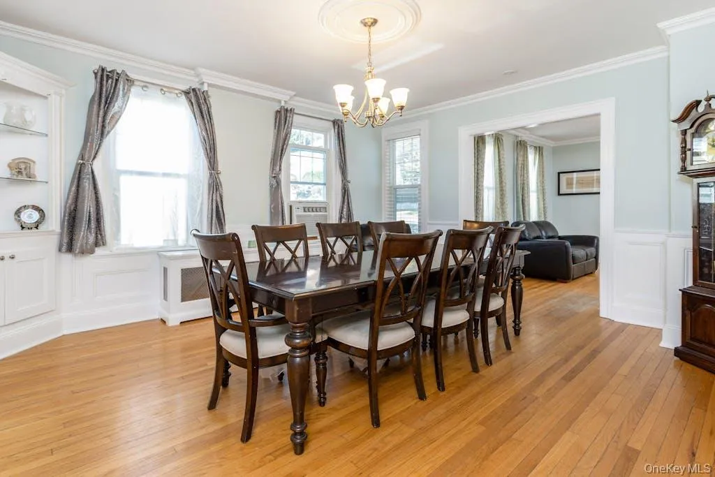 Dining space featuring light hardwood / wood-style floors, a chandelier, and ornamental molding Dining space featuring light hardwood / wood-style floors, a chandelier, and ornamental molding