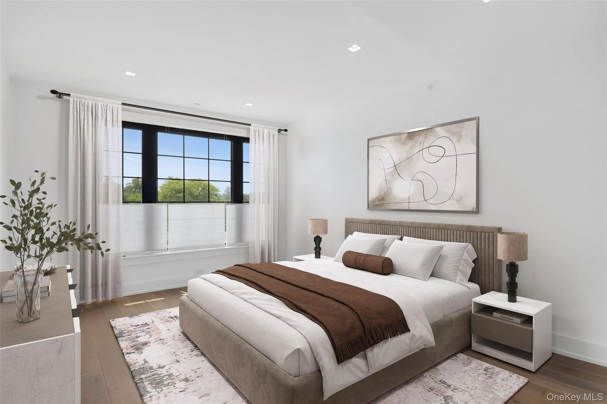 Light-filled room featuring wood-finish flooring, recessed lighting, and a large multi-pane window with dark frames Light-filled room featuring wood-finish flooring, recessed lighting, and a large multi-pane window with dark frames