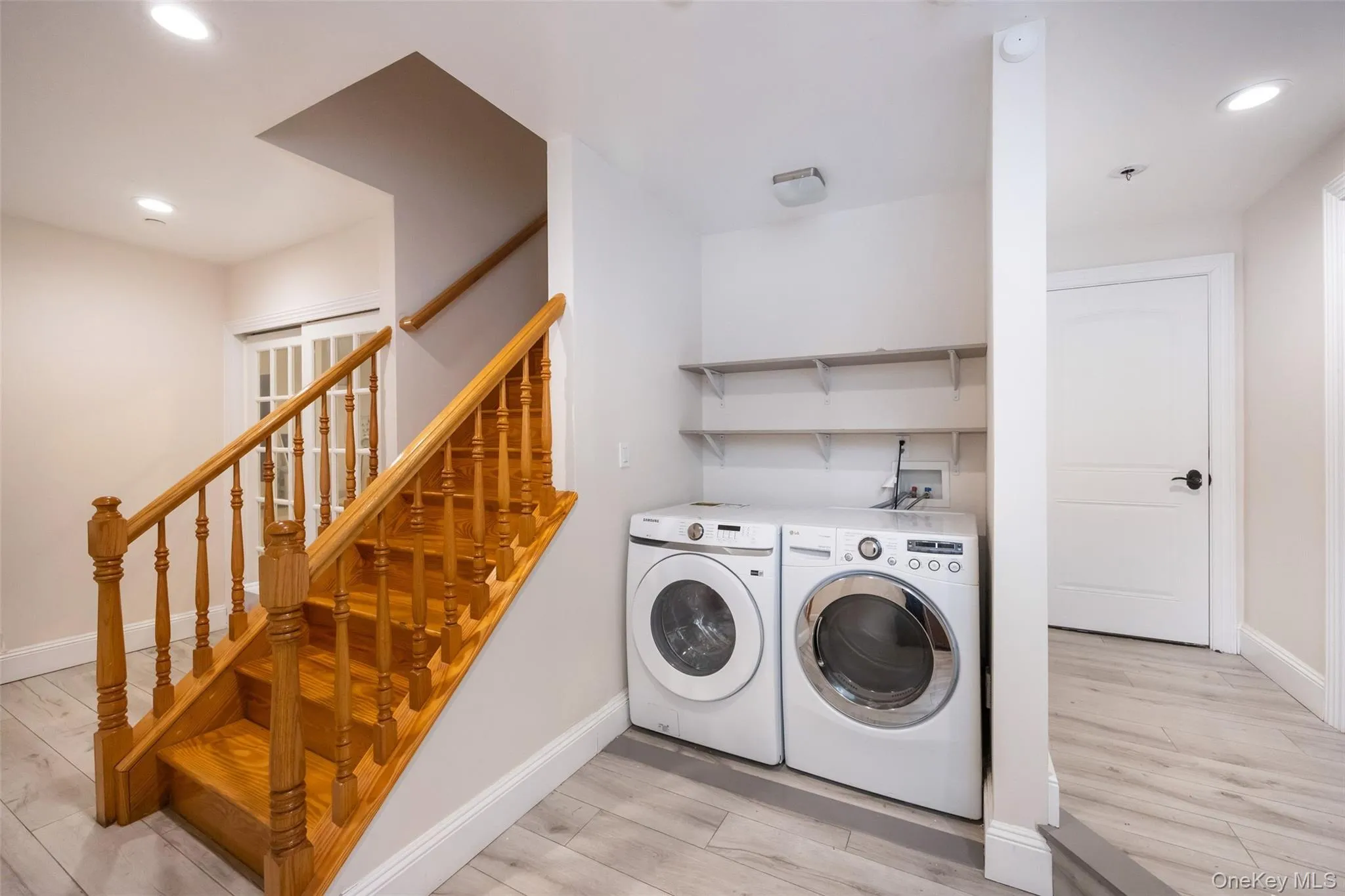 Washroom with separate washer and dryer, light wood-style floors, baseboards, and recessed lighting Washroom with separate washer and dryer, light wood-style floors, baseboards, and recessed lighting