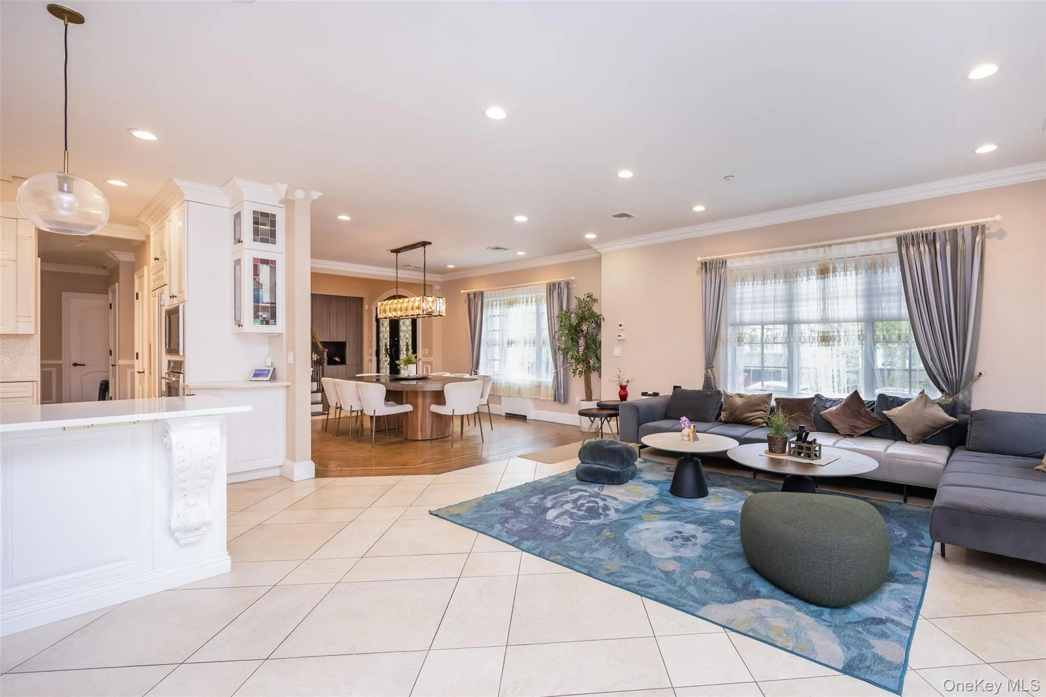 Living room featuring crown molding, light tile patterned flooring, recessed lighting, and baseboards Living room featuring crown molding, light tile patterned flooring, recessed lighting, and baseboards