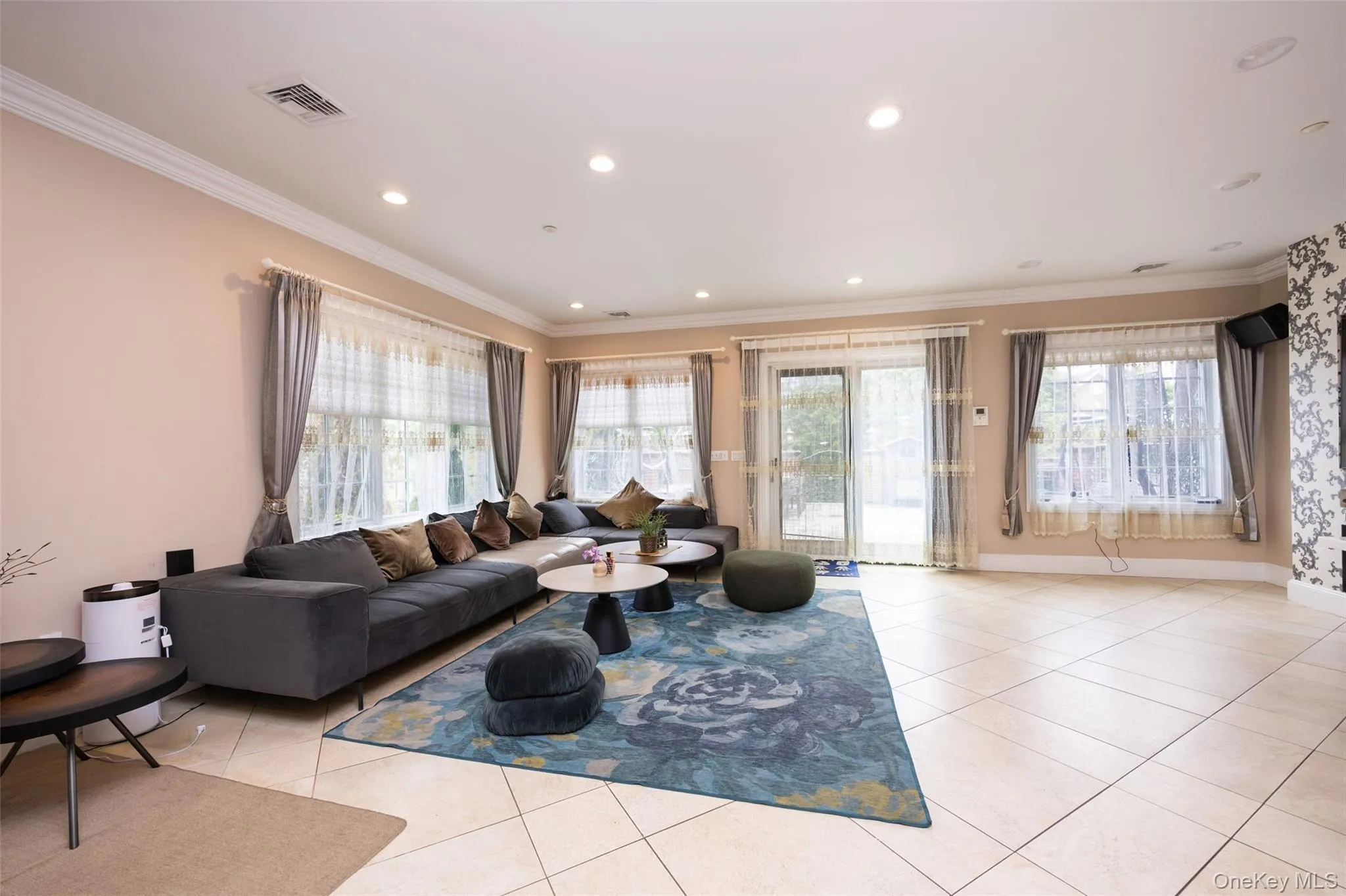 Living room featuring light tile patterned floors, ornamental molding, and recessed lighting Living room featuring light tile patterned floors, ornamental molding, and recessed lighting