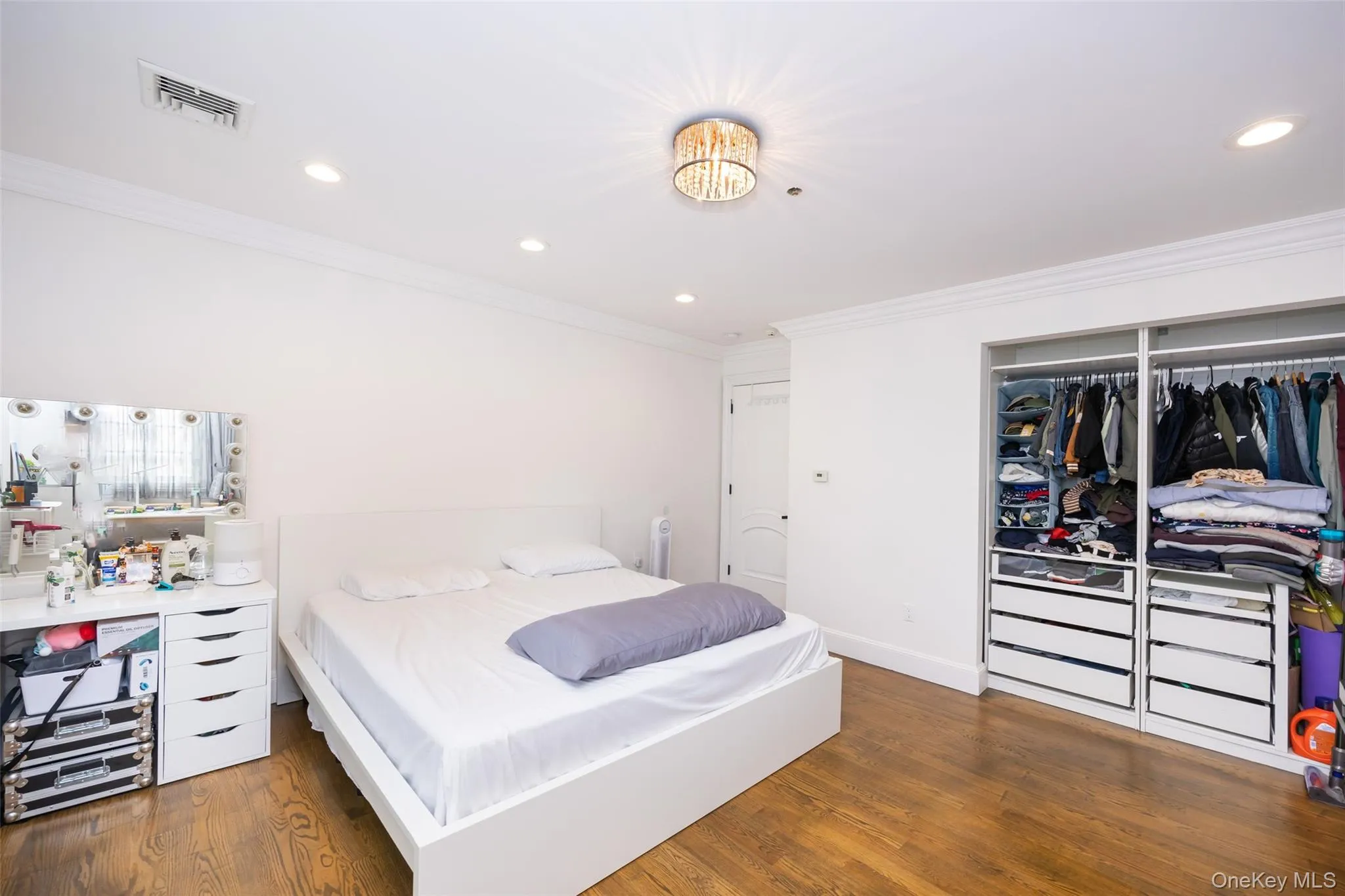 Bedroom featuring crown molding, recessed lighting, wood finished floors, a closet, and baseboards Bedroom featuring crown molding, recessed lighting, wood finished floors, a closet, and baseboards