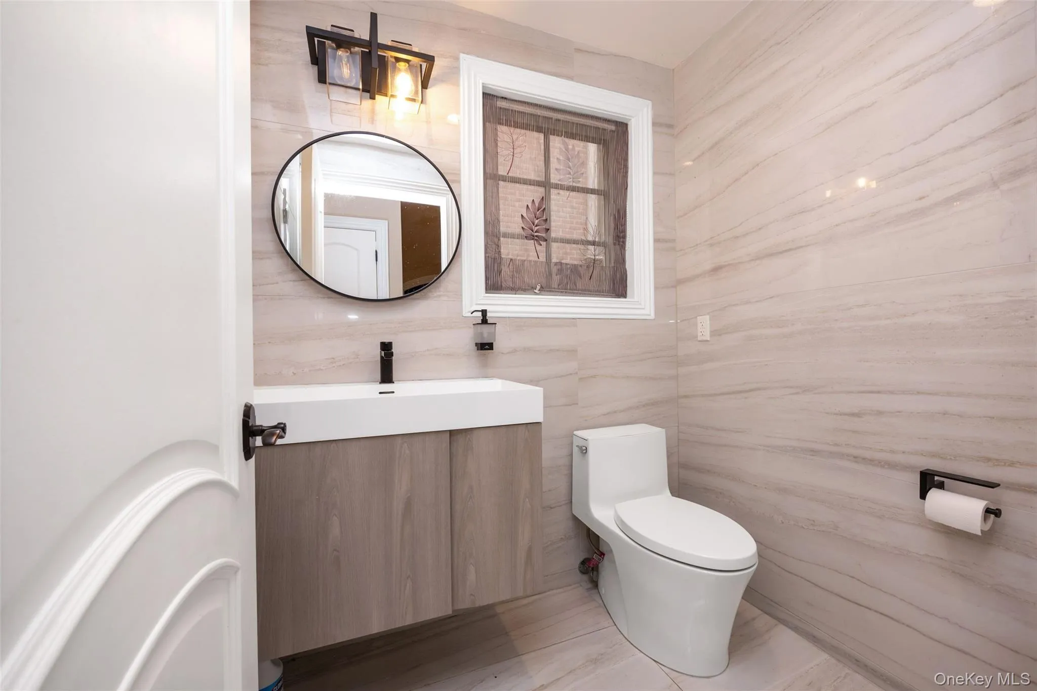 Half bath featuring toilet, tile walls, and vanity Half bath featuring toilet, tile walls, and vanity