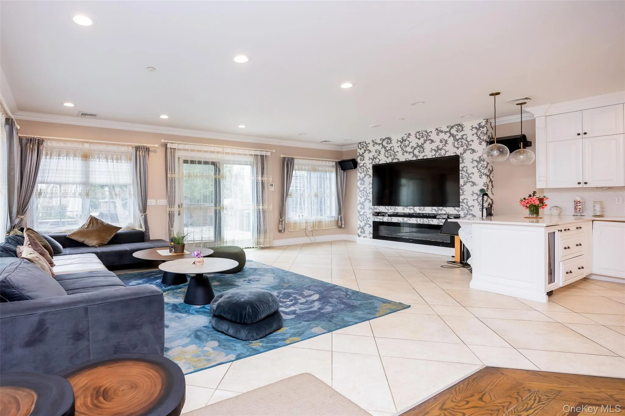 Living area featuring light tile patterned floors, ornamental molding, and recessed lighting Living area featuring light tile patterned floors, ornamental molding, and recessed lighting