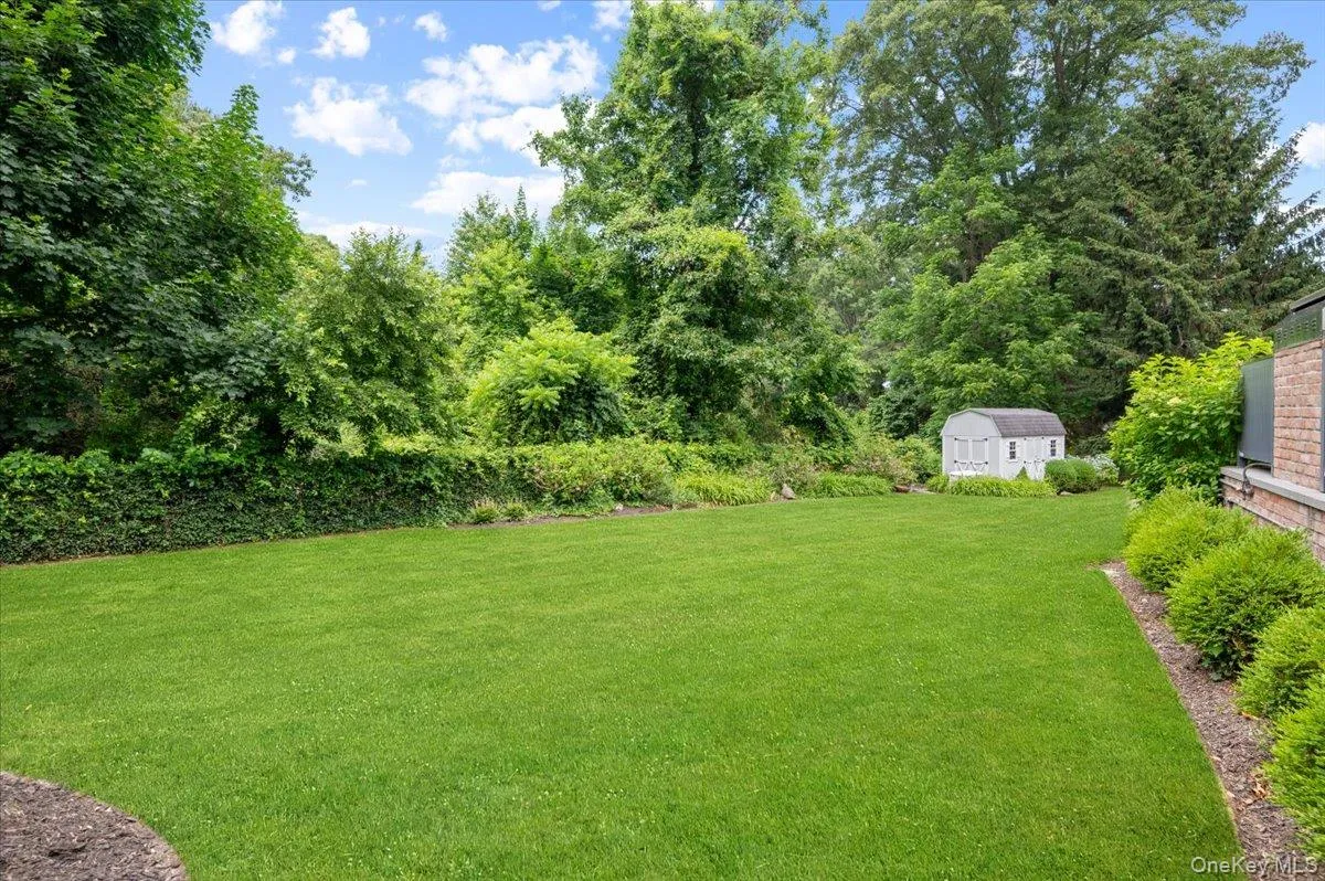 Expansive lawn area featuring a white storage shed Expansive lawn area featuring a white storage shed