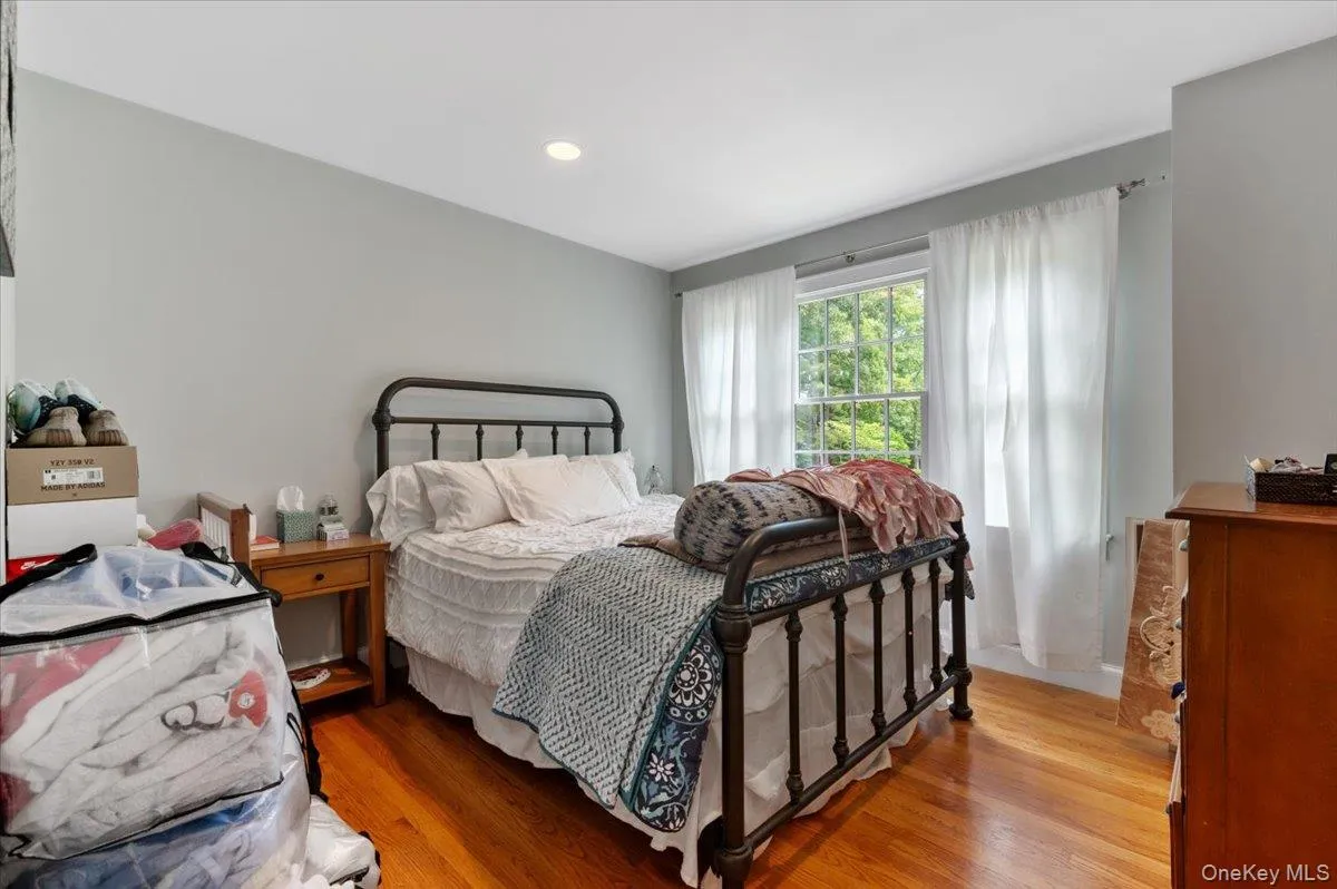 Room featuring hardwood flooring, recessed lighting, and a window with natural light Room featuring hardwood flooring, recessed lighting, and a window with natural light