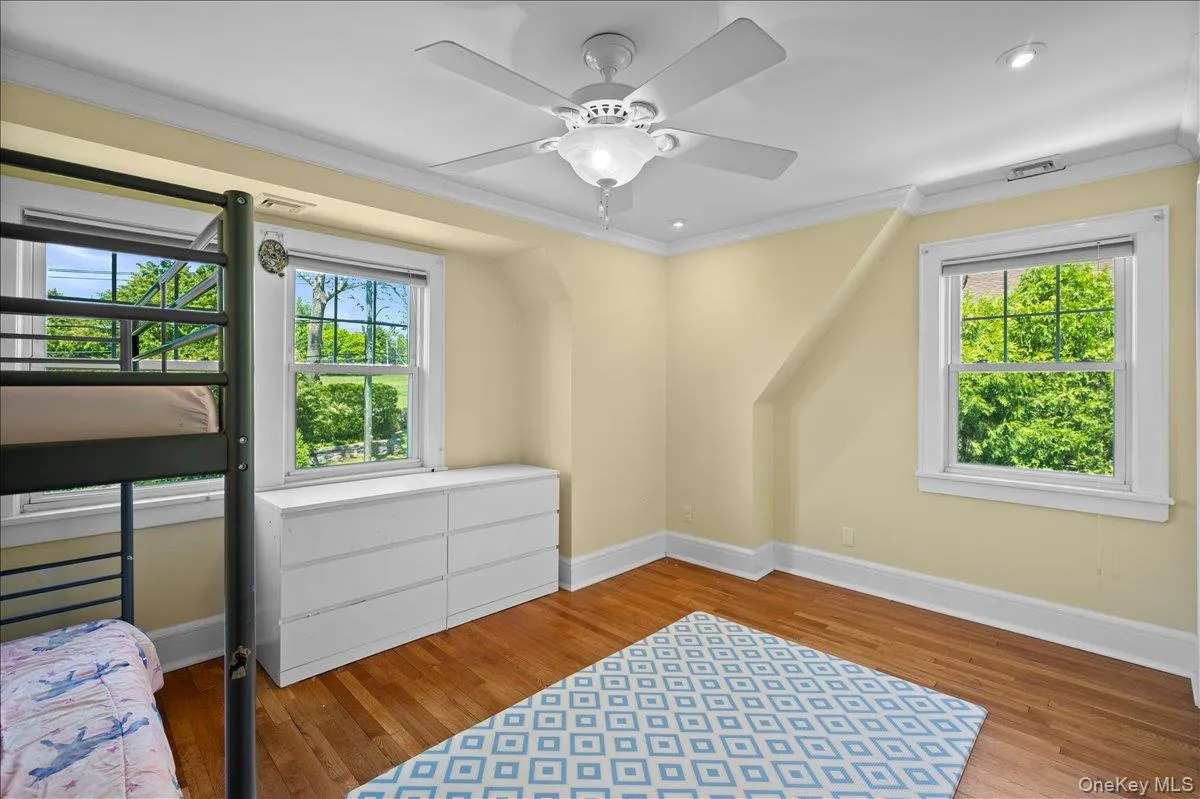 Hardwood flooring, recessed lighting, and a ceiling fan fixture highlight this room Hardwood flooring, recessed lighting, and a ceiling fan fixture highlight this room