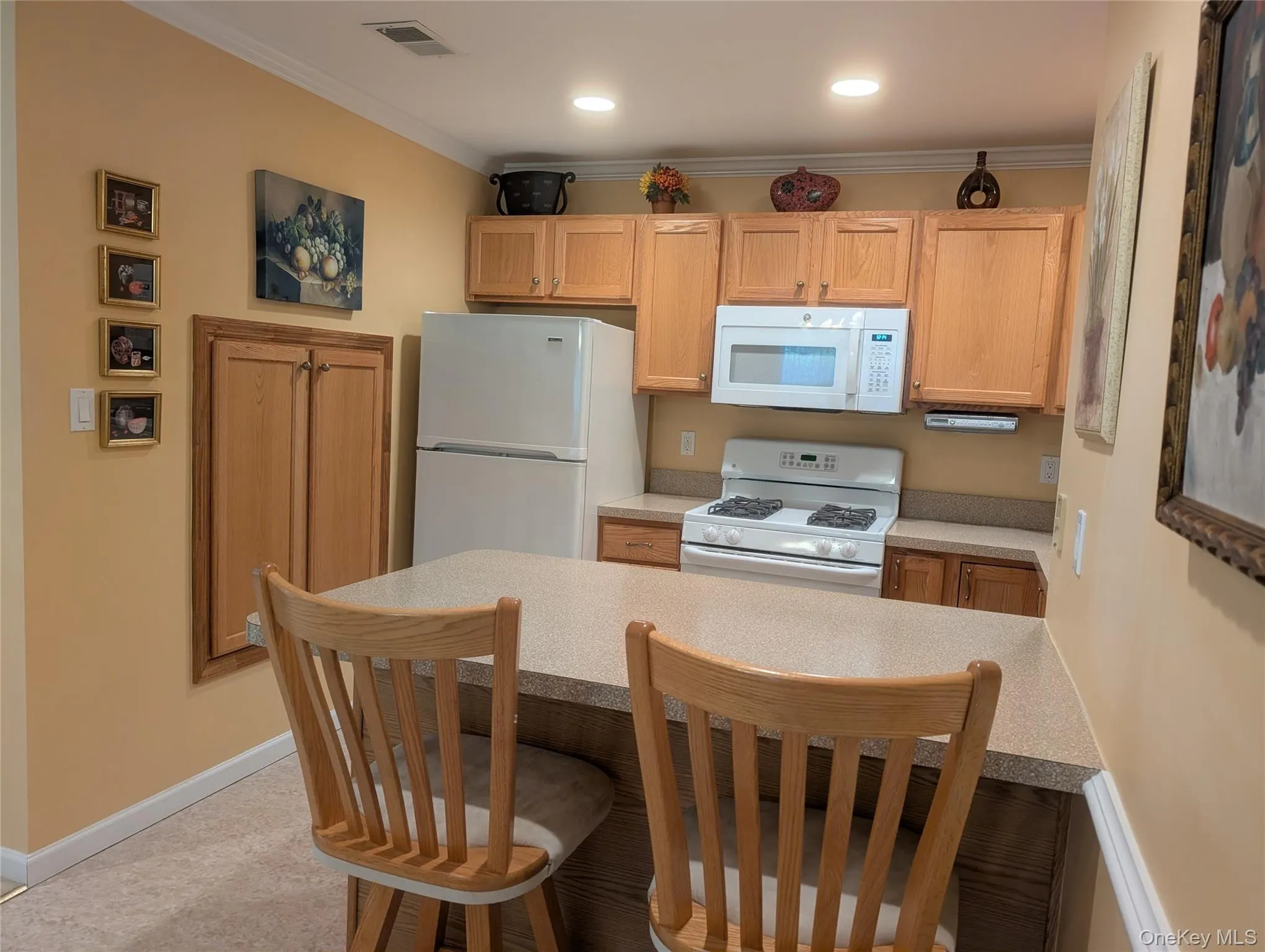 Kitchen featuring light wood cabinetry, recessed lighting, a built-in Pantry and a peninsula with countertop seating Kitchen featuring light wood cabinetry, recessed lighting, a built-in Pantry and a peninsula with countertop seating