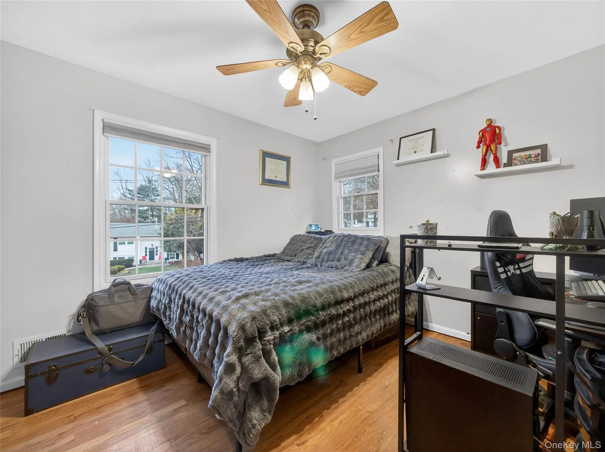 Bedroom featuring an office area, wood finished floors, and ceiling fan Bedroom featuring an office area, wood finished floors, and ceiling fan