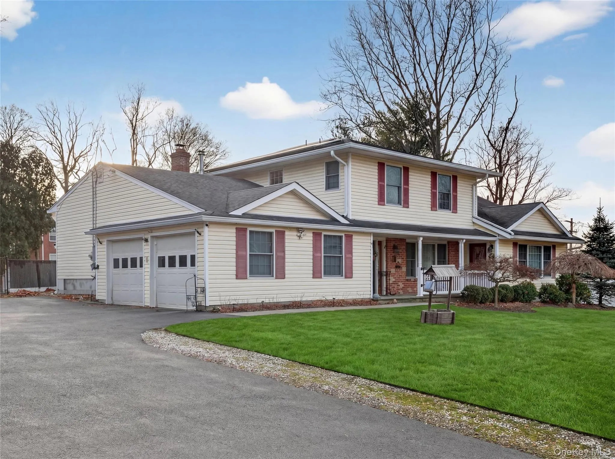 Traditional-style house with a porch, a front lawn, a garage, and driveway Traditional-style house with a porch, a front lawn, a garage, and driveway