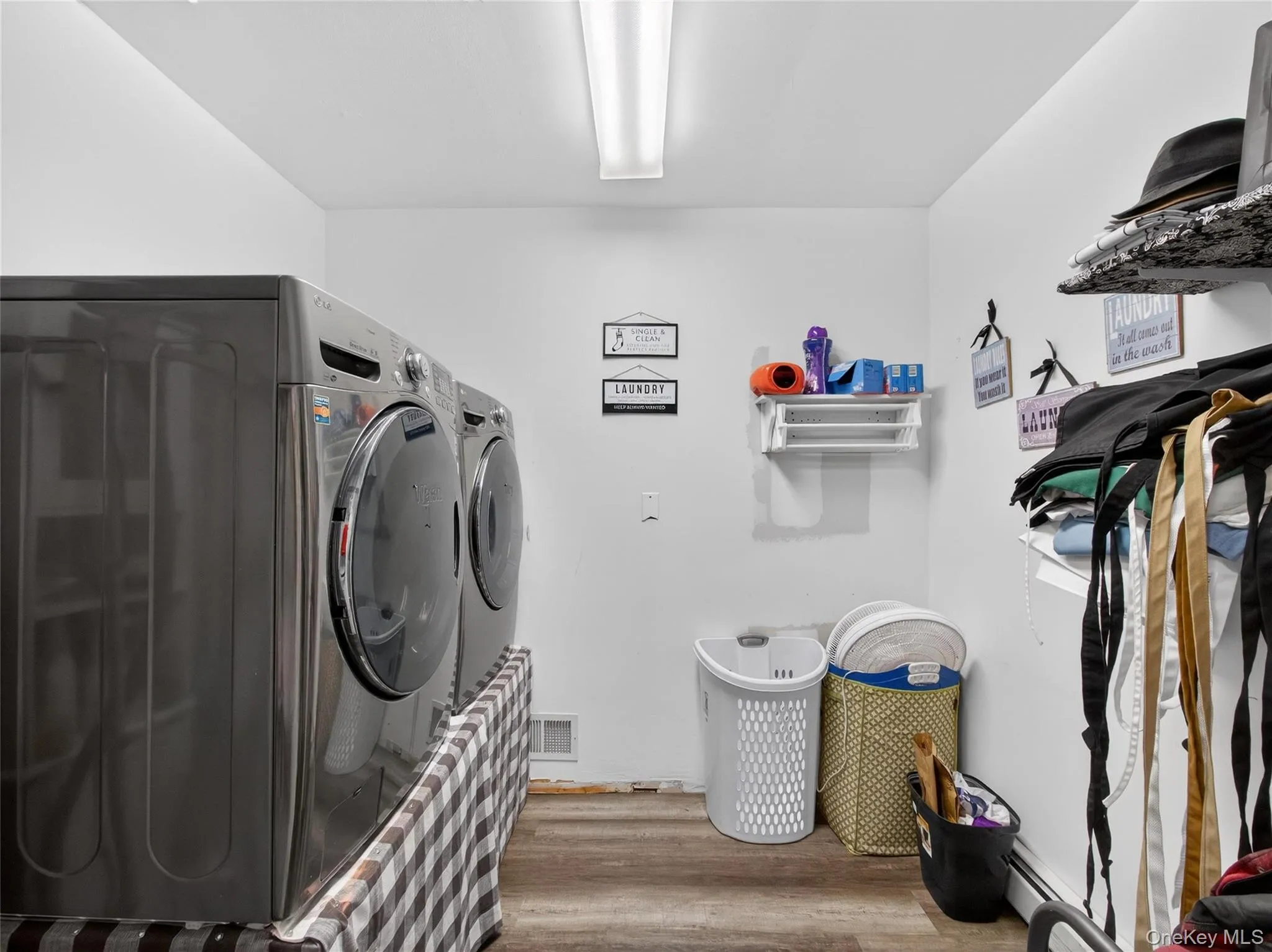 Washroom with wood finished floors and washing machine and dryer Washroom with wood finished floors and washing machine and dryer