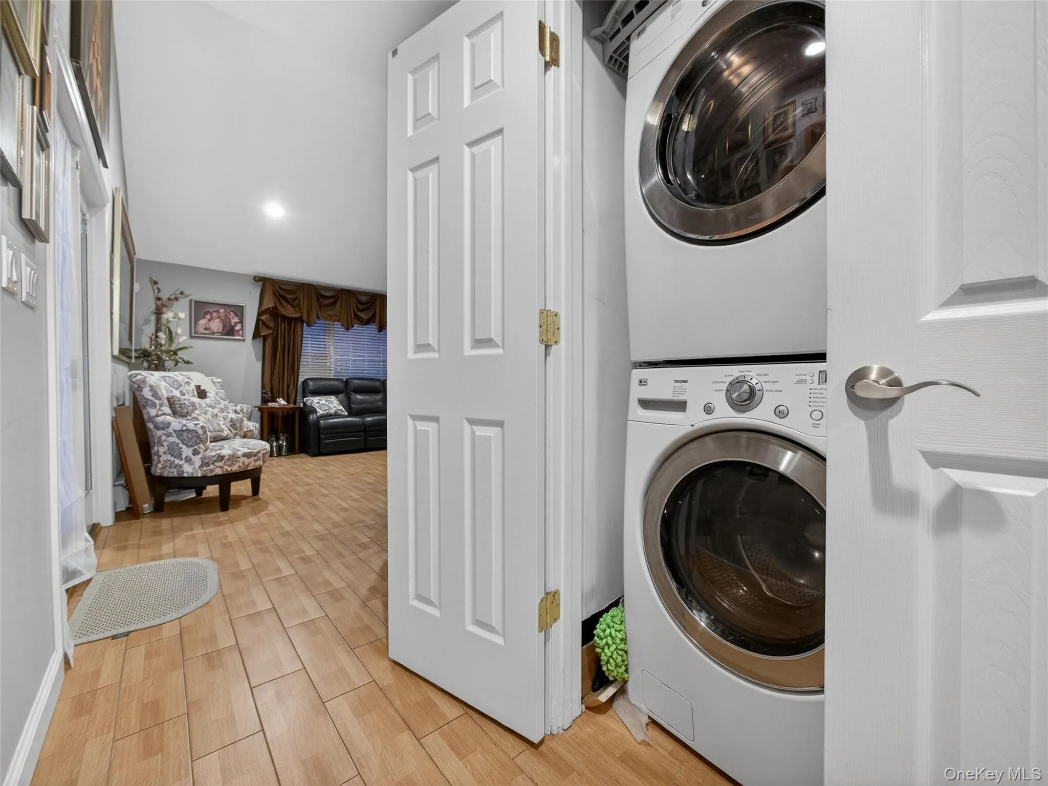 Washroom featuring estacked washer and dryer and wood tiled floors Washroom featuring estacked washer and dryer and wood tiled floors