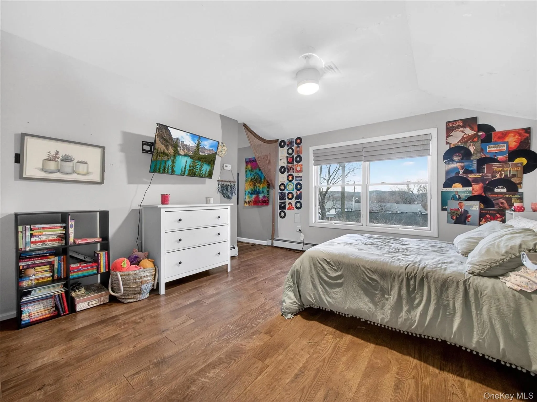 Bedroom featuring wood finished floors, a baseboard heating unit, and lofted ceiling Bedroom featuring wood finished floors, a baseboard heating unit, and lofted ceiling