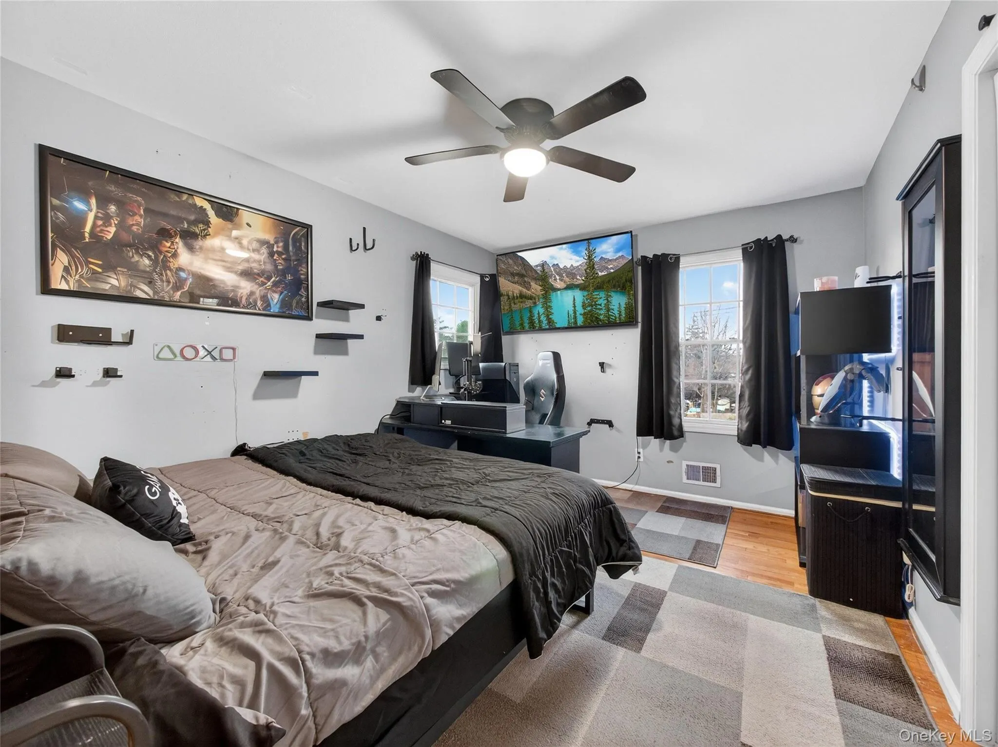 Bedroom with multiple windows, ceiling fan, and wood finished floors Bedroom with multiple windows, ceiling fan, and wood finished floors