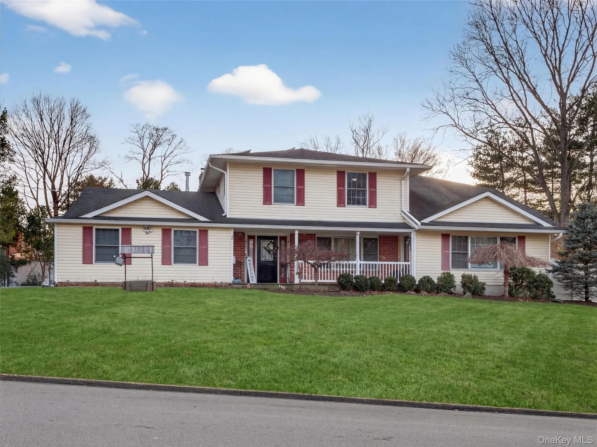Traditional-style home featuring covered porch and a front lawn Traditional-style home featuring covered porch and a front lawn