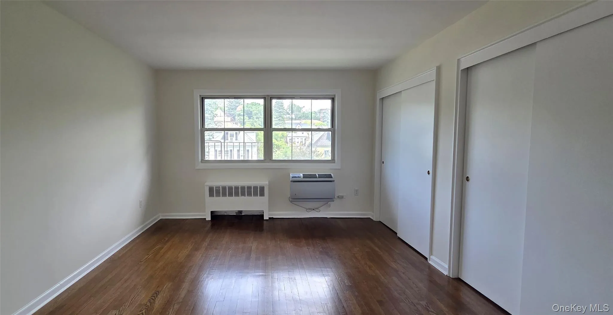 Spacious primary bedroom with wall of closets Spacious primary bedroom with wall of closets