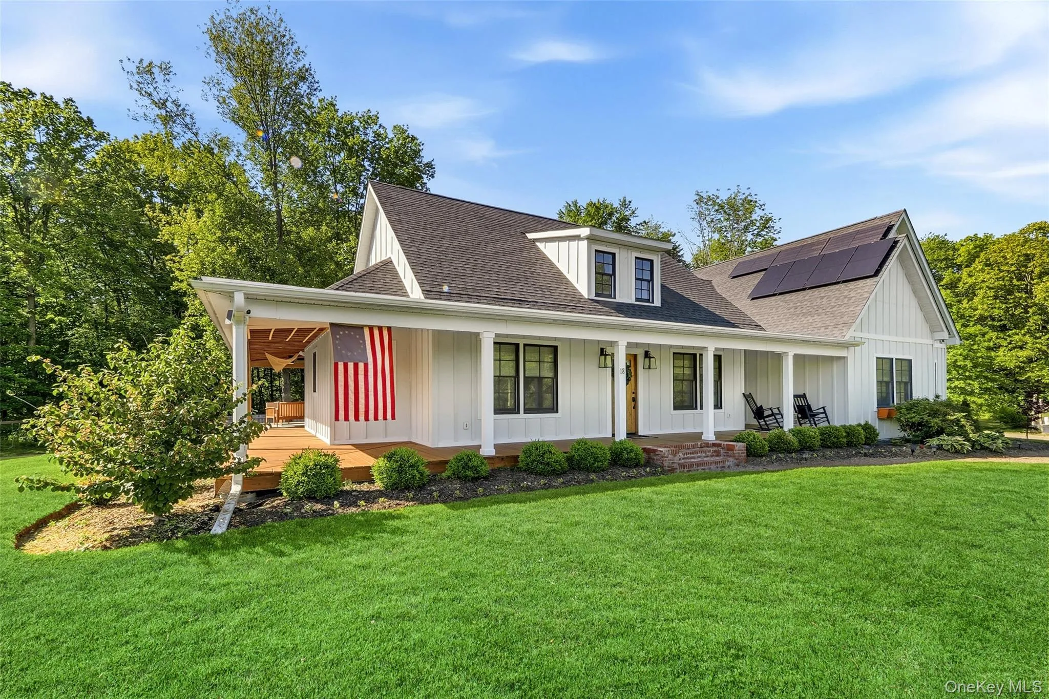Front exterior view highlighting the wraparound porch and picturesque surroundings Front exterior view highlighting the wraparound porch and picturesque surroundings